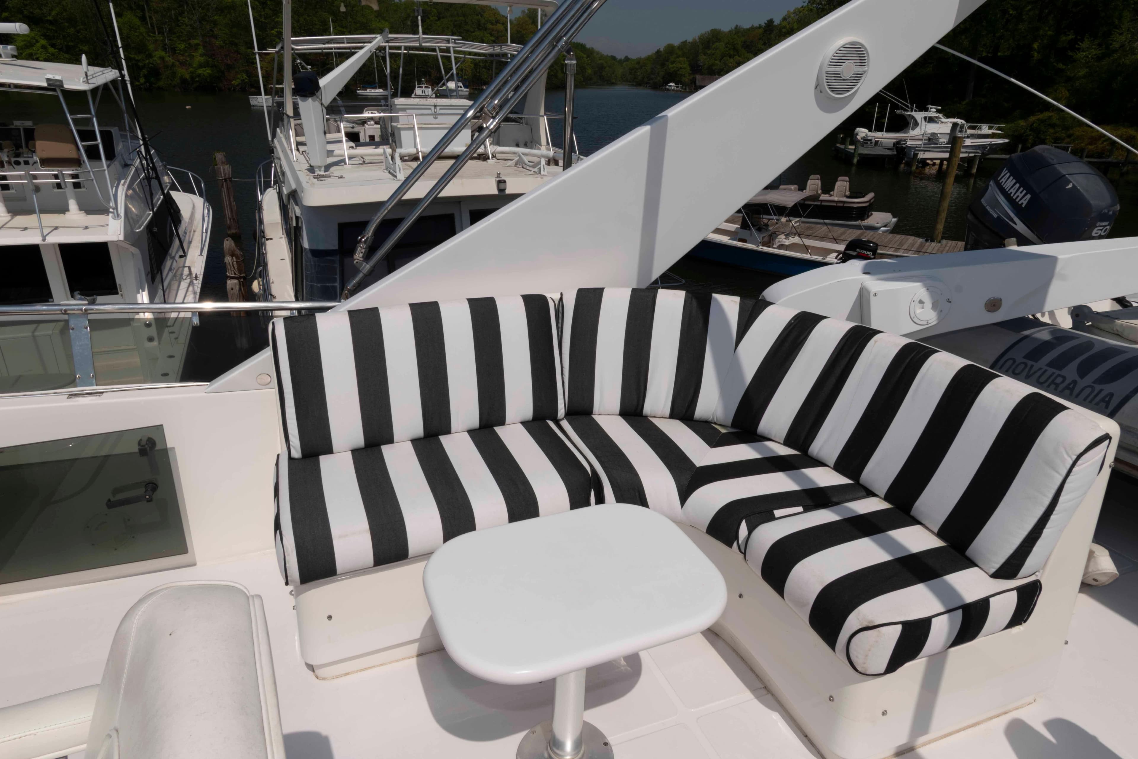 Luxurious 1999 West Bay 58 Sonship Pilothouse yacht with striped seating on deck.