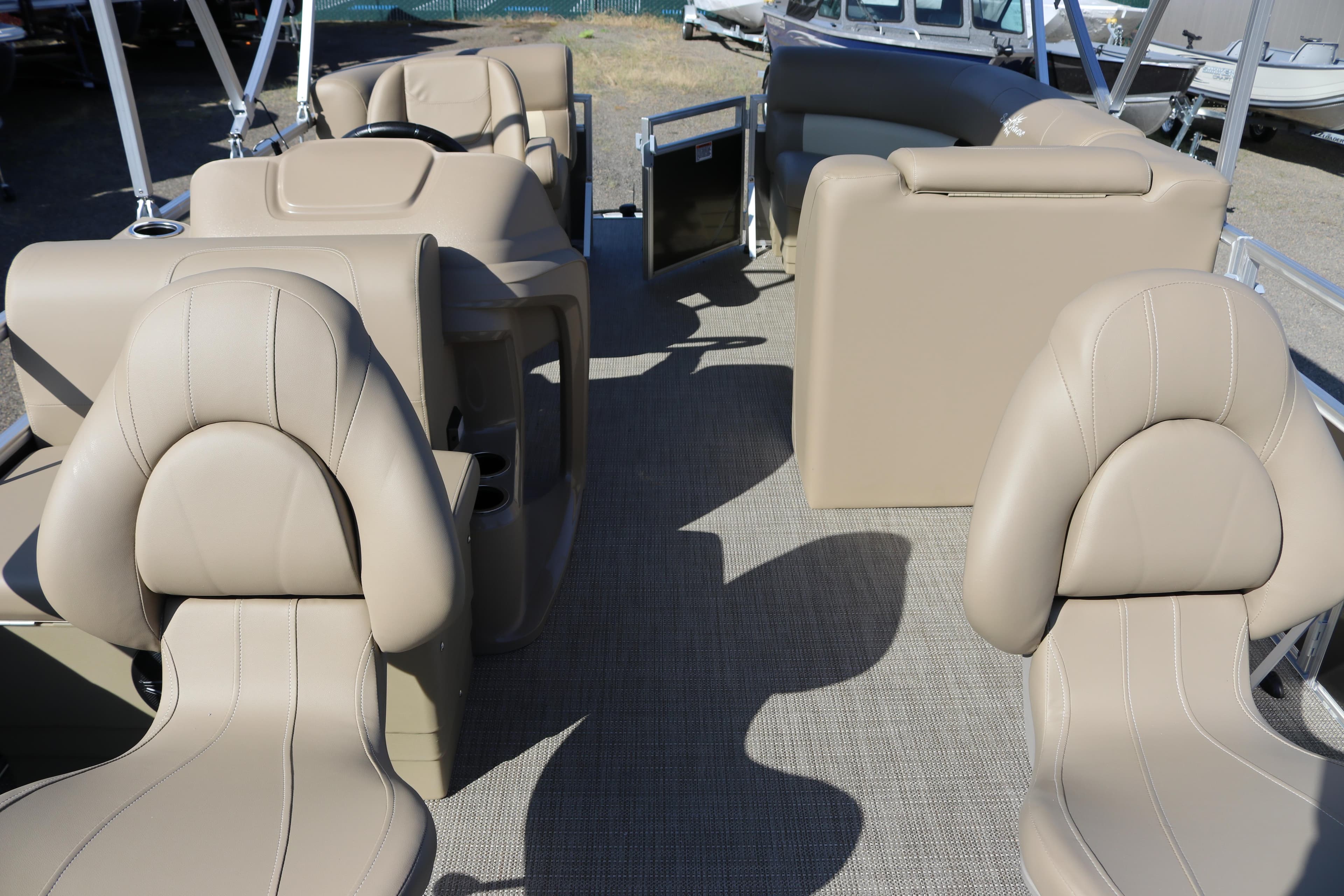 2025 SunChaser Vista 18 Fish boat interior with beige seating and steering console.