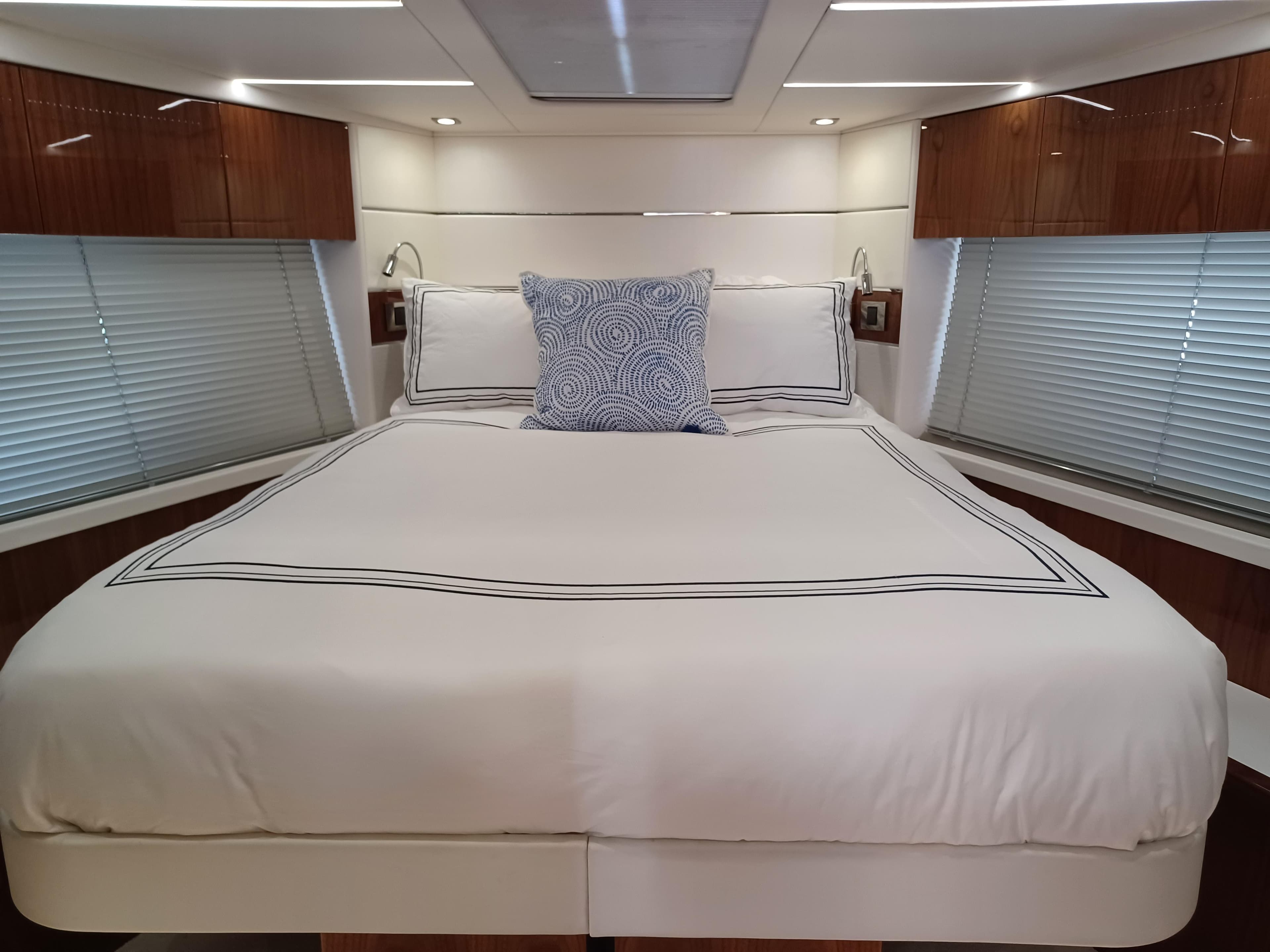 Luxurious bedroom interior of 2020 Sunseeker Predator 50 yacht with elegant bedding.