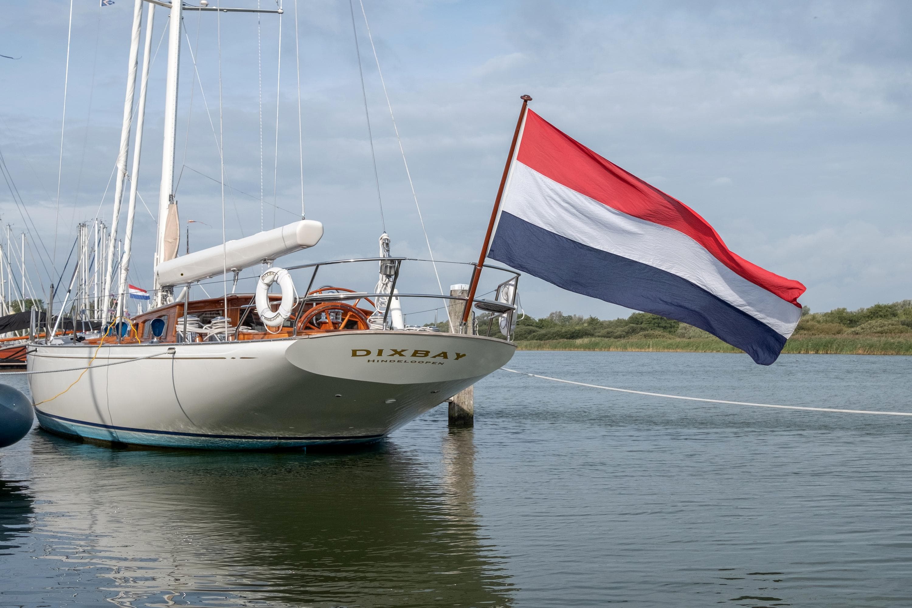 Sailing yacht Hoek Classic 73 (2004) with Dutch flag in a serene harbor.