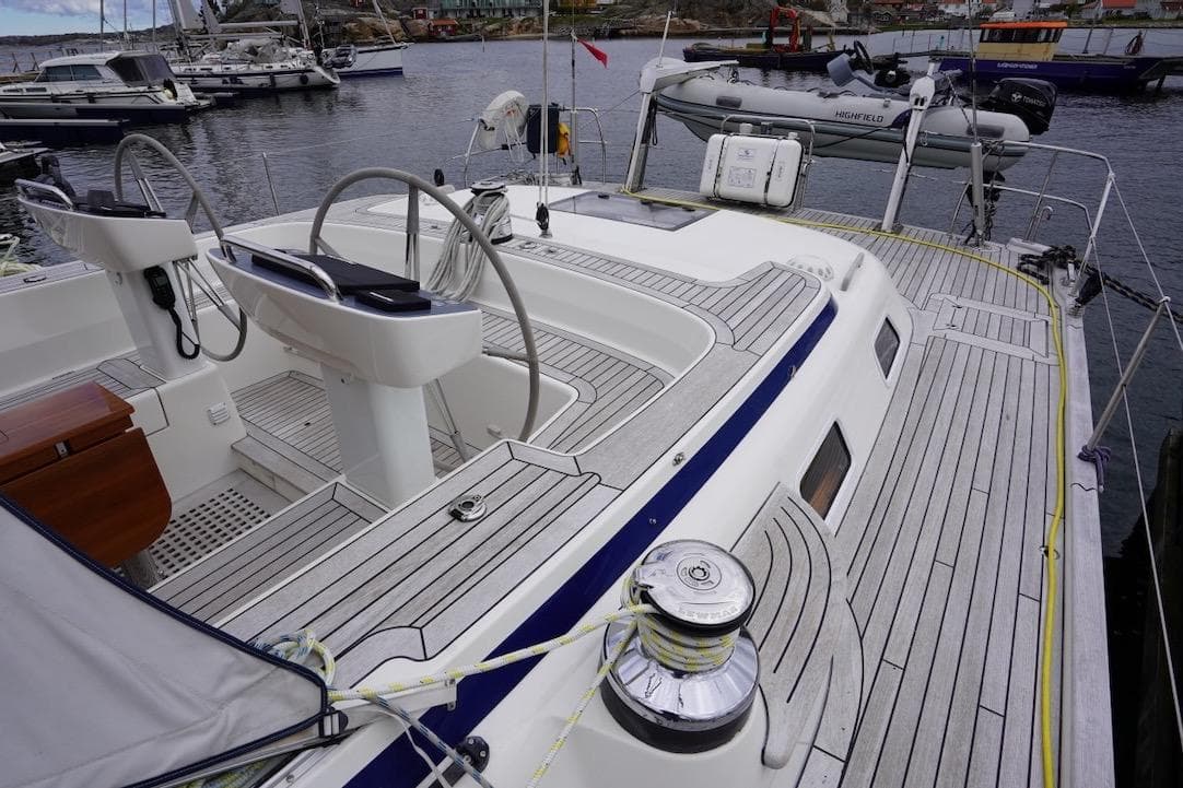 2020 Hallberg-Rassy 57 yacht deck with dual steering wheels and sleek design in marina.