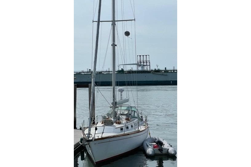 1983 Bristol 38.8 sailboat docked with inflatable dinghy alongside.