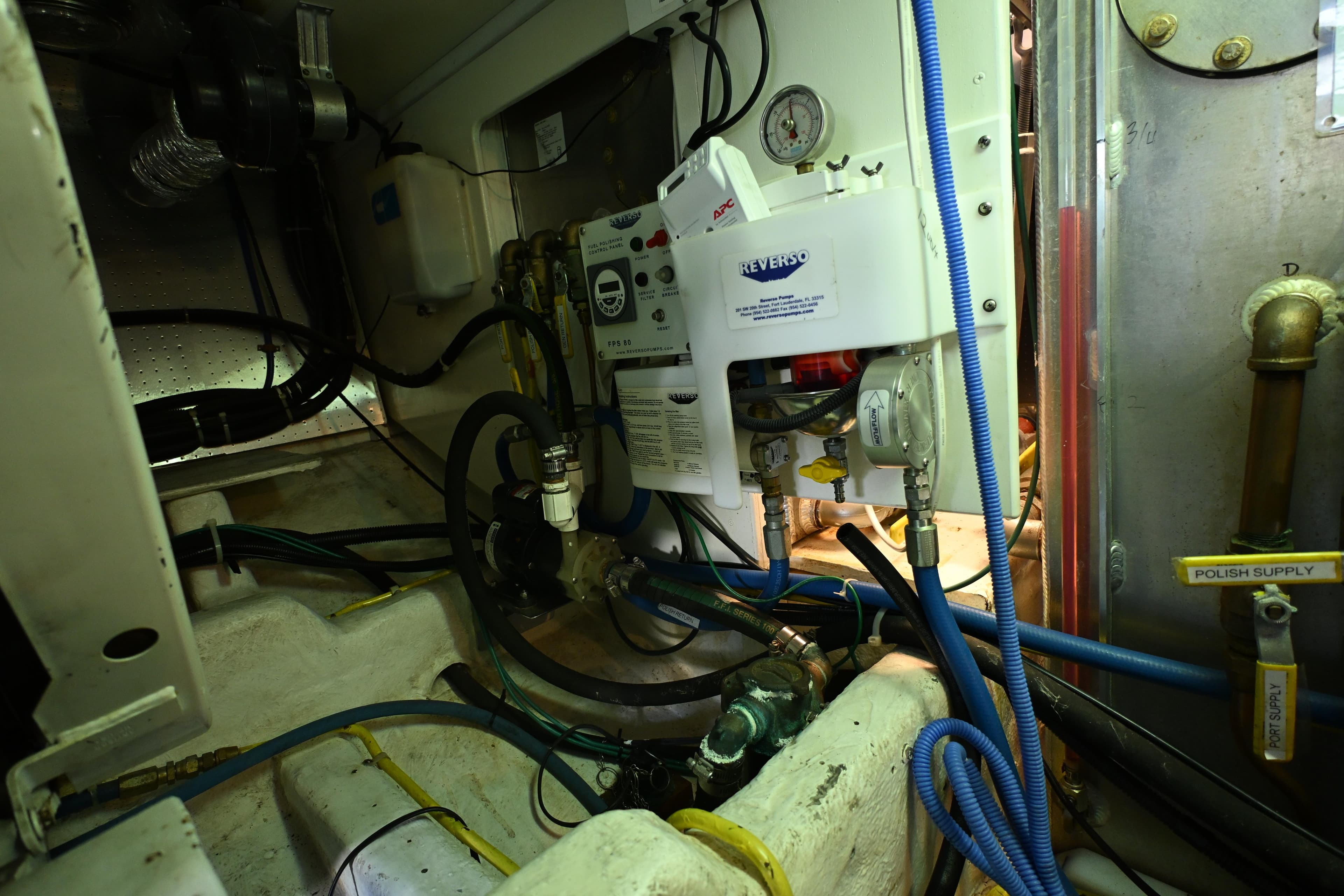 Engine room of a 1999 McKinna 47 Sedan with various mechanical components and wiring.