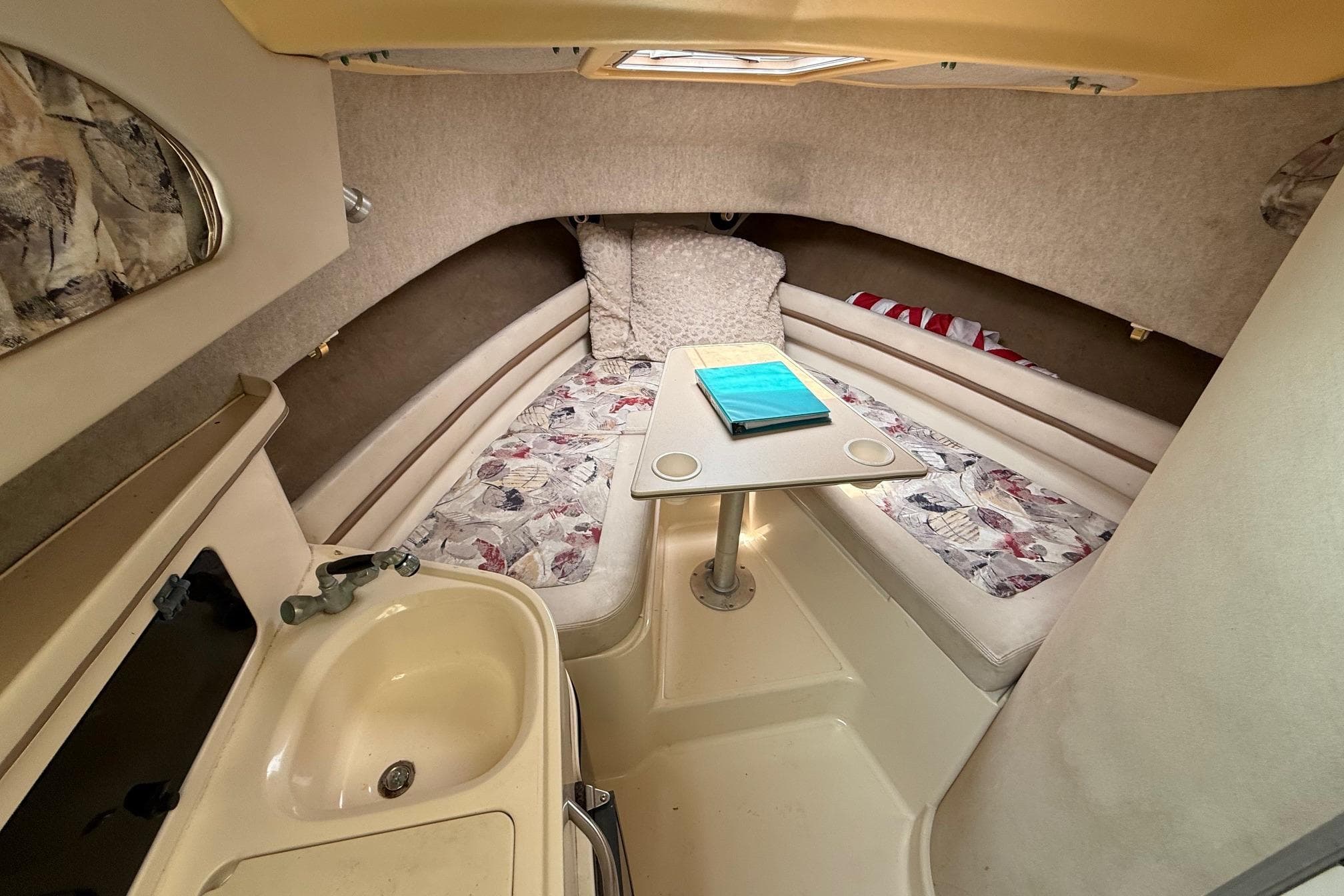 1999 Grady-White Marlin 300 cabin interior with seating, table, and sink.