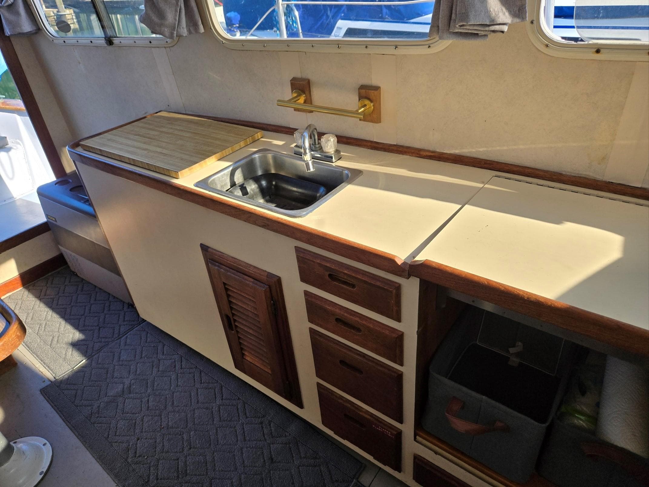 1974 Willard Nomad boat interior with sink, wooden cabinets, and countertop.