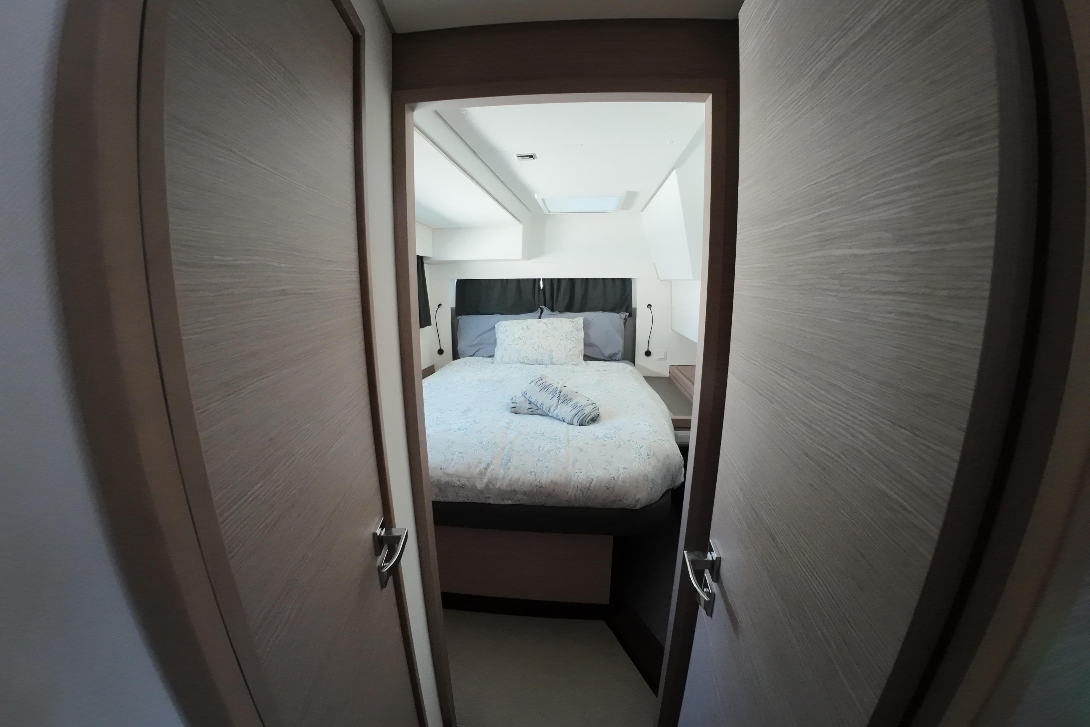 Luxurious bedroom interior of 2022 Fountaine Pajot Tanna 47 yacht, featuring cozy bedding.