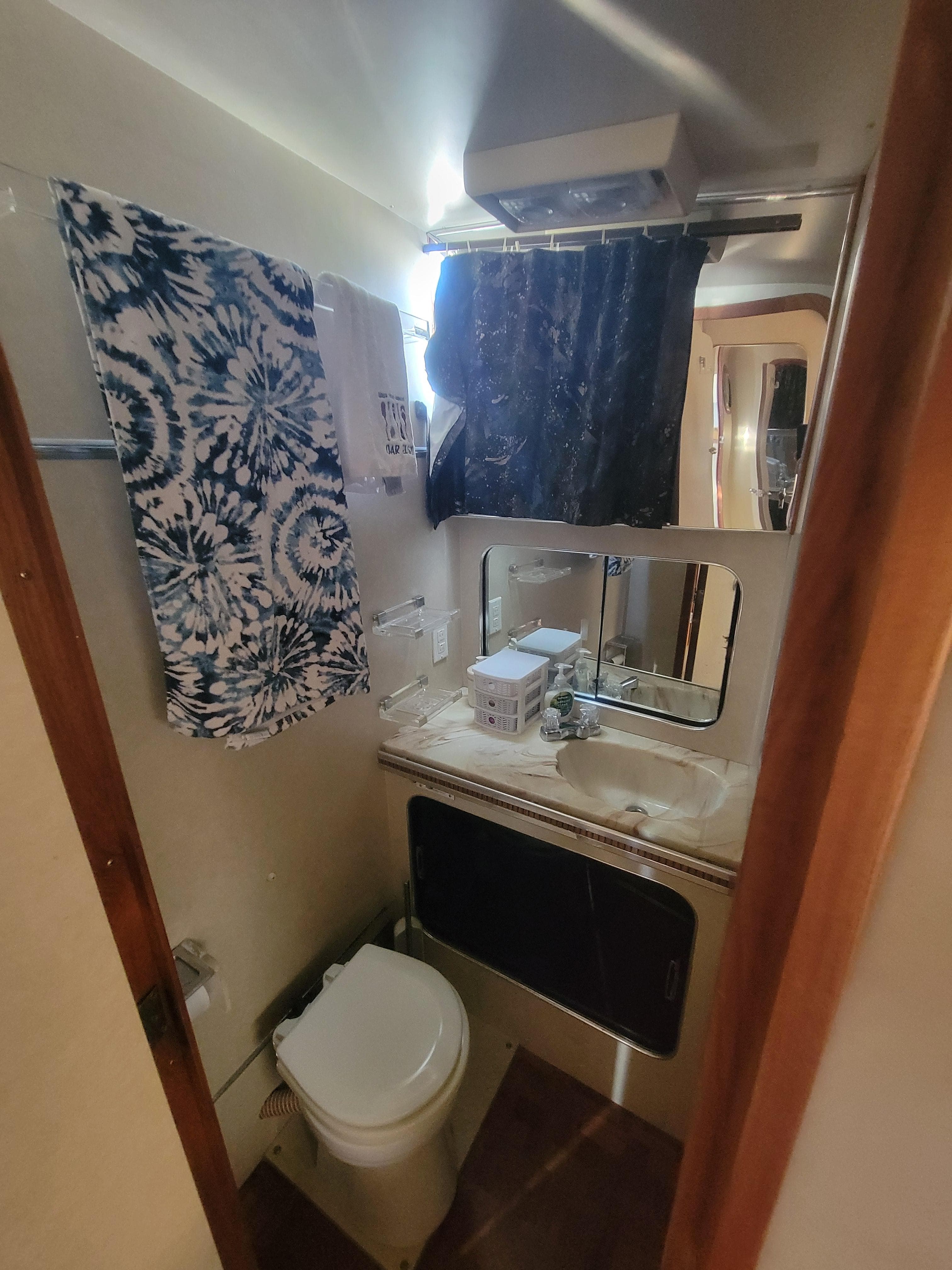1986 Chris-Craft 381 Catalina bathroom with toilet, sink, and patterned towel.