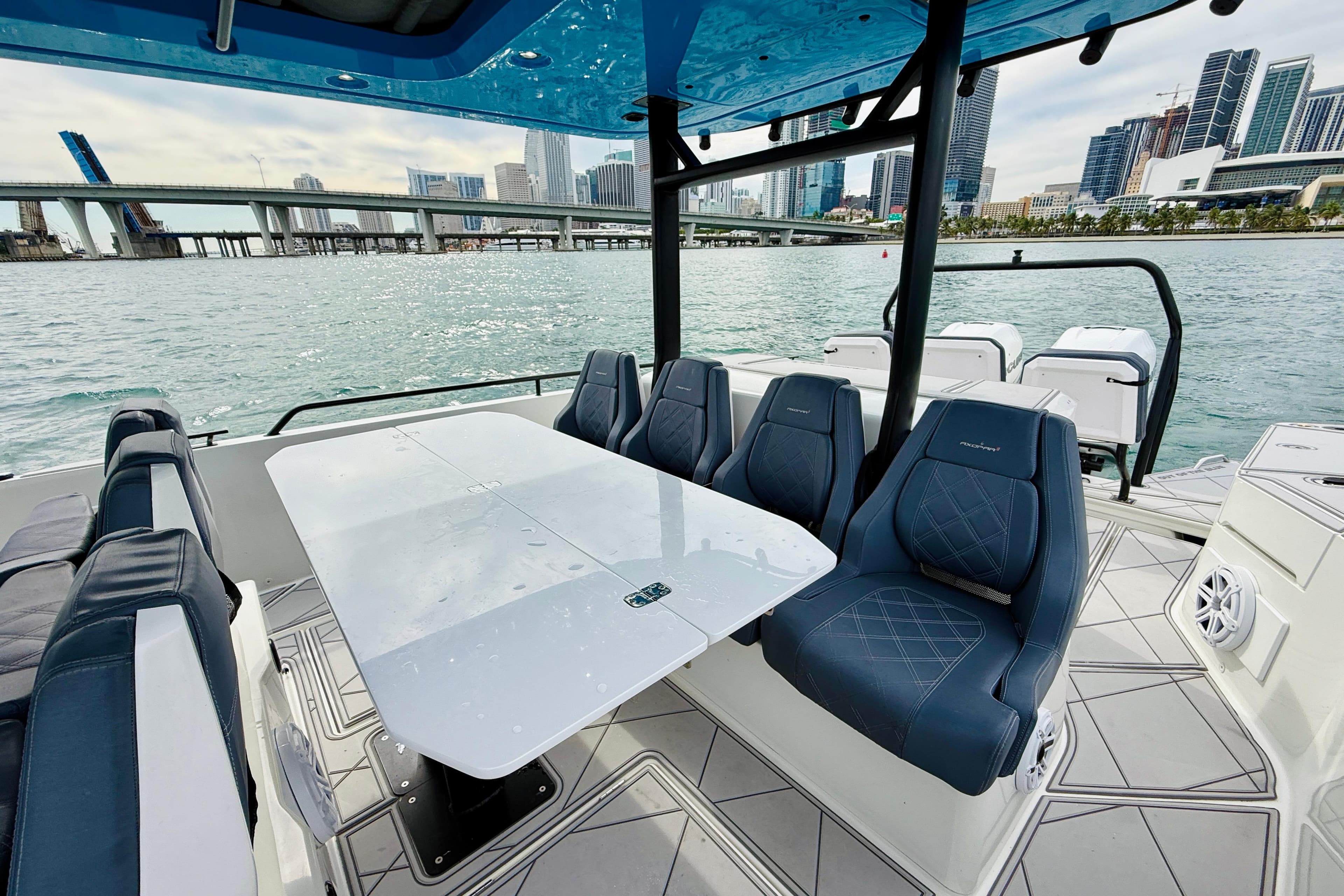 2021 Axopar 37 Sun Top boat interior with seating and table, city skyline view.