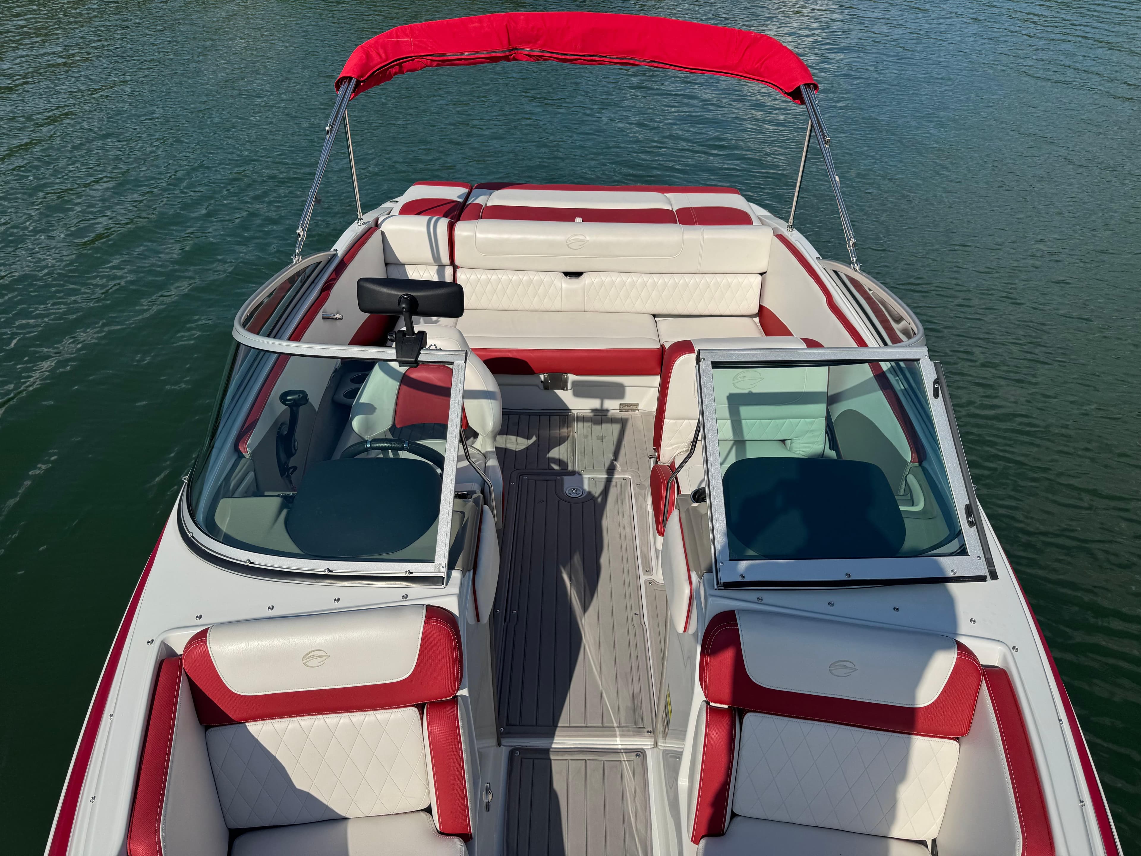 2018 Crownline 225SS boat with red and white interior on calm water.