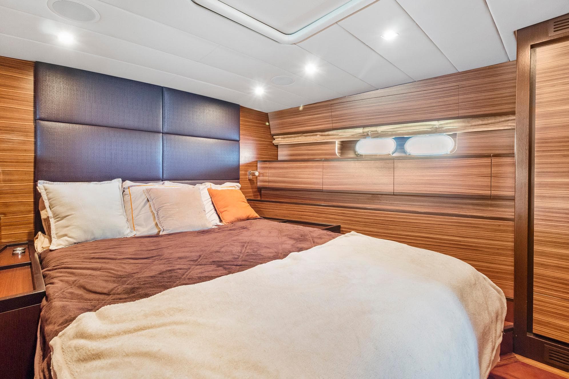 Luxurious bedroom interior of 2007 Leopard Express Motor Yacht with wood paneling and cozy bedding.