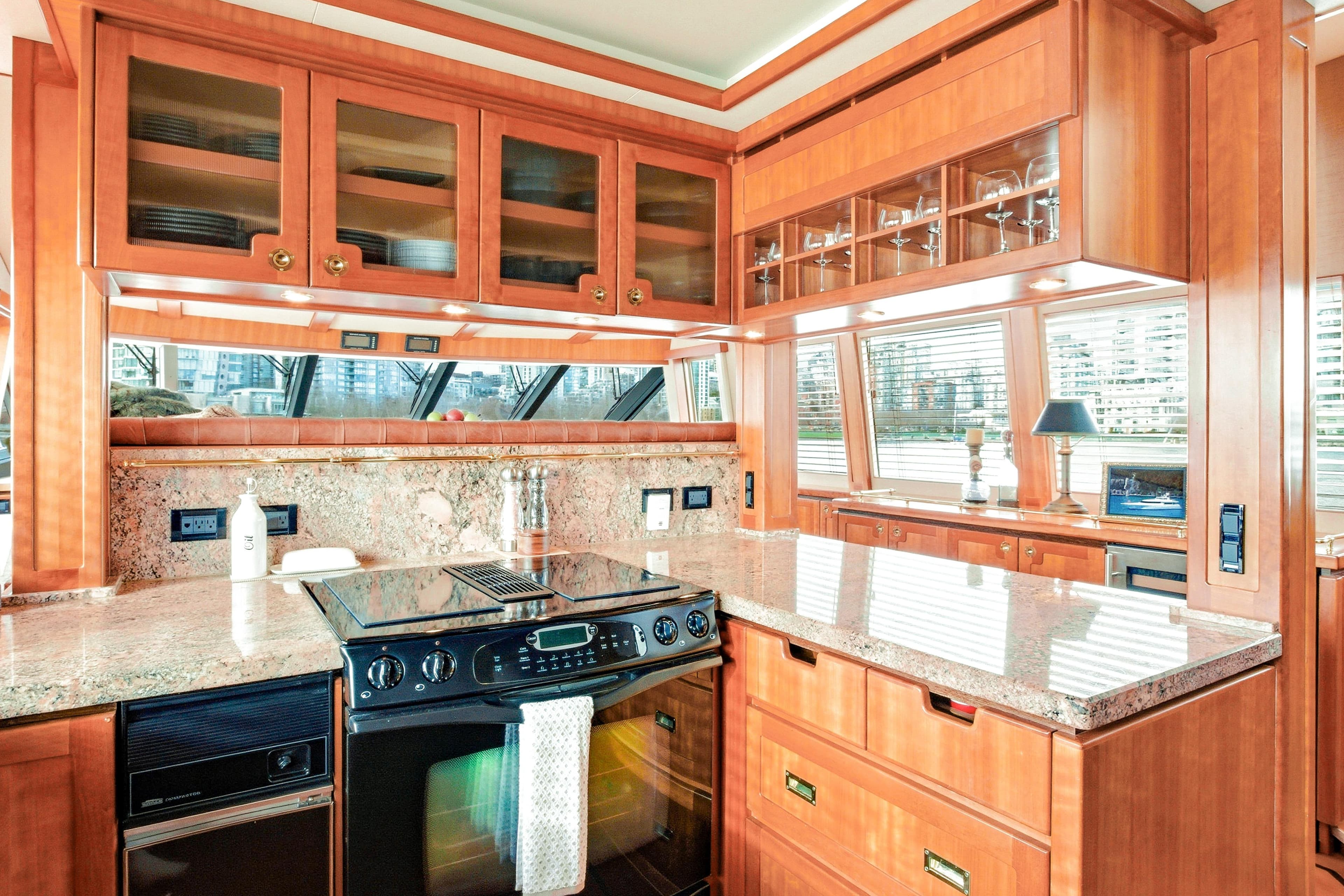 Luxurious 2003 West Bay Sonship yacht kitchen with wood cabinetry and granite countertops.