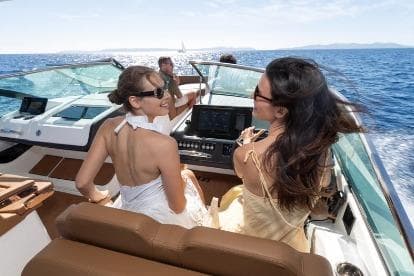 Two women enjoying a sunny day on a 2026 Jeanneau TH33 boat.