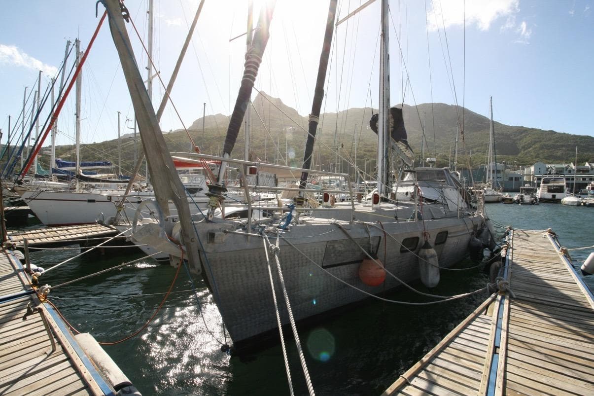 Sailboat docked at marina, Custom Southwell Sovereign 51, 2019, with mountainous backdrop.