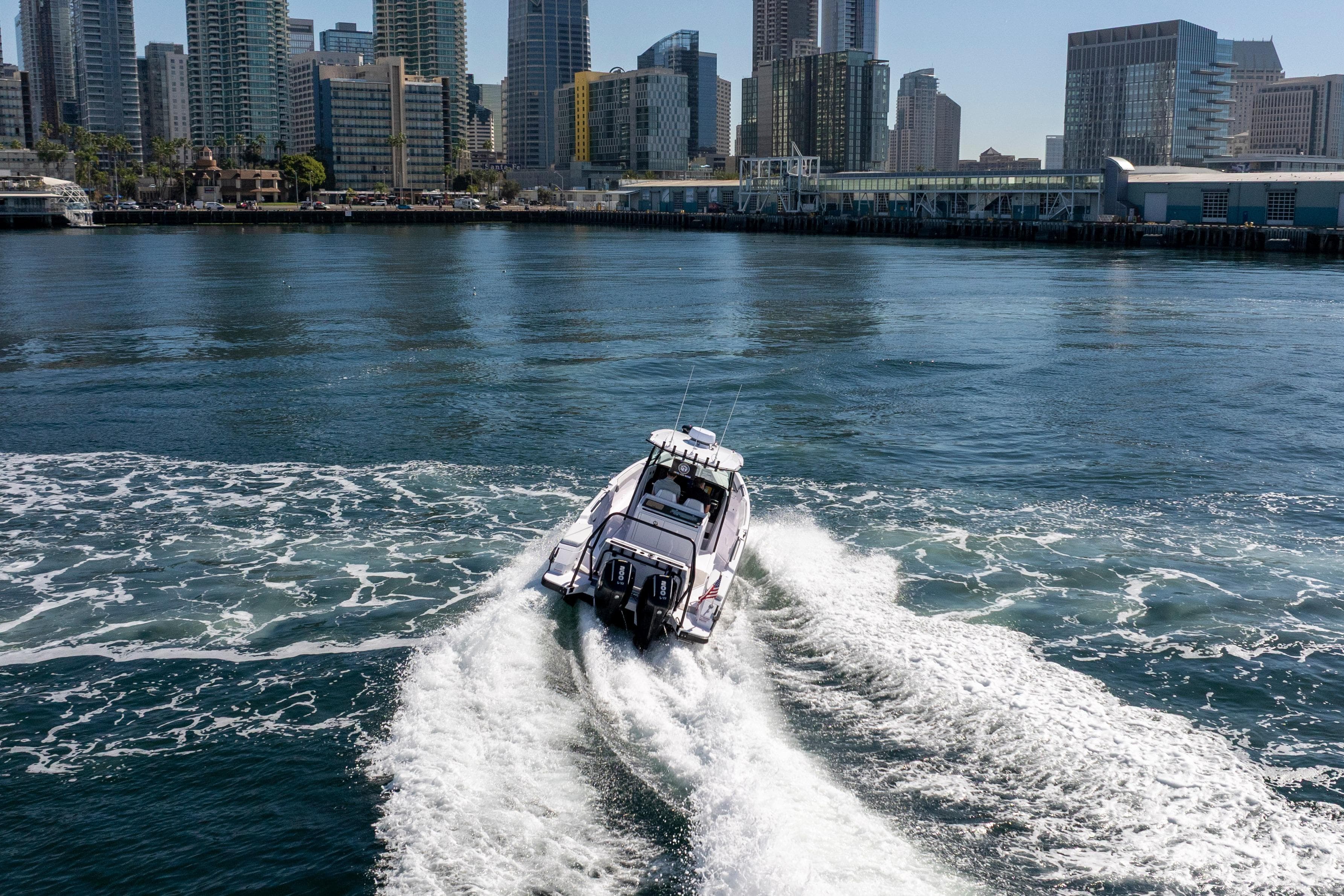 2026 Axopar AX29 CCX cruising in urban waterfront setting.