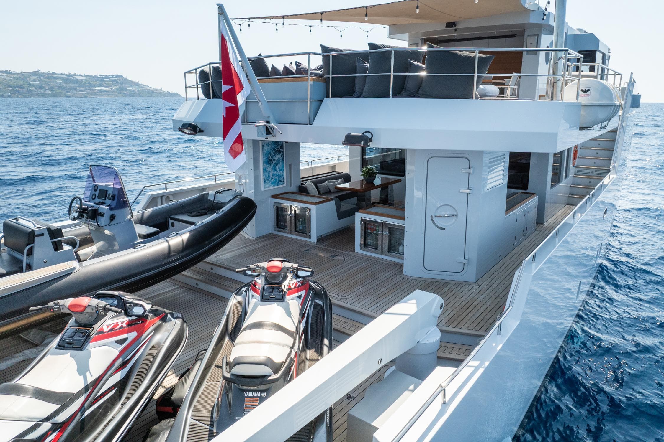Luxurious 2011 Tansu Custom yacht with jet skis and spacious deck on open sea.