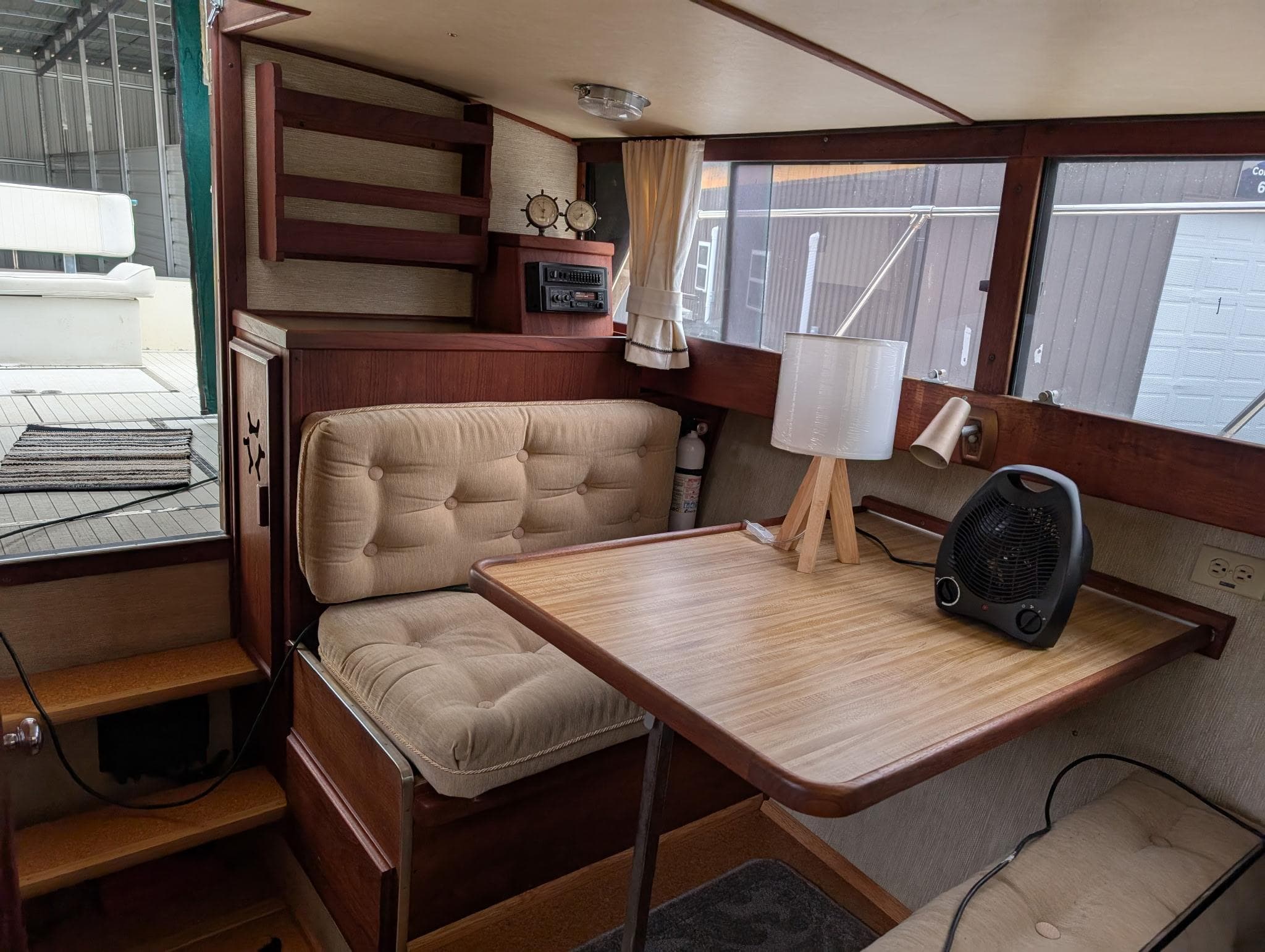 1989 Marinette 28 Sport Fish Fly Bridge interior with cozy seating and wooden table.