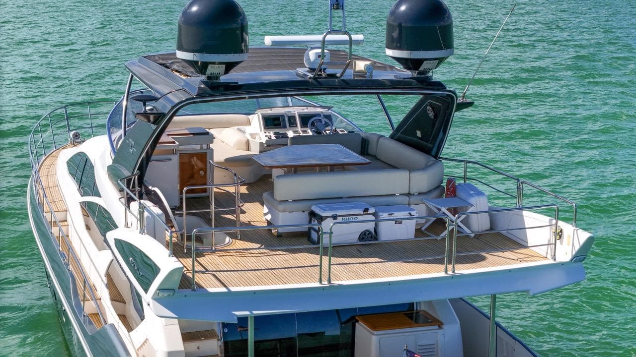 Luxurious 2012 Azimut Flybridge yacht on serene water, featuring spacious deck and modern amenities.