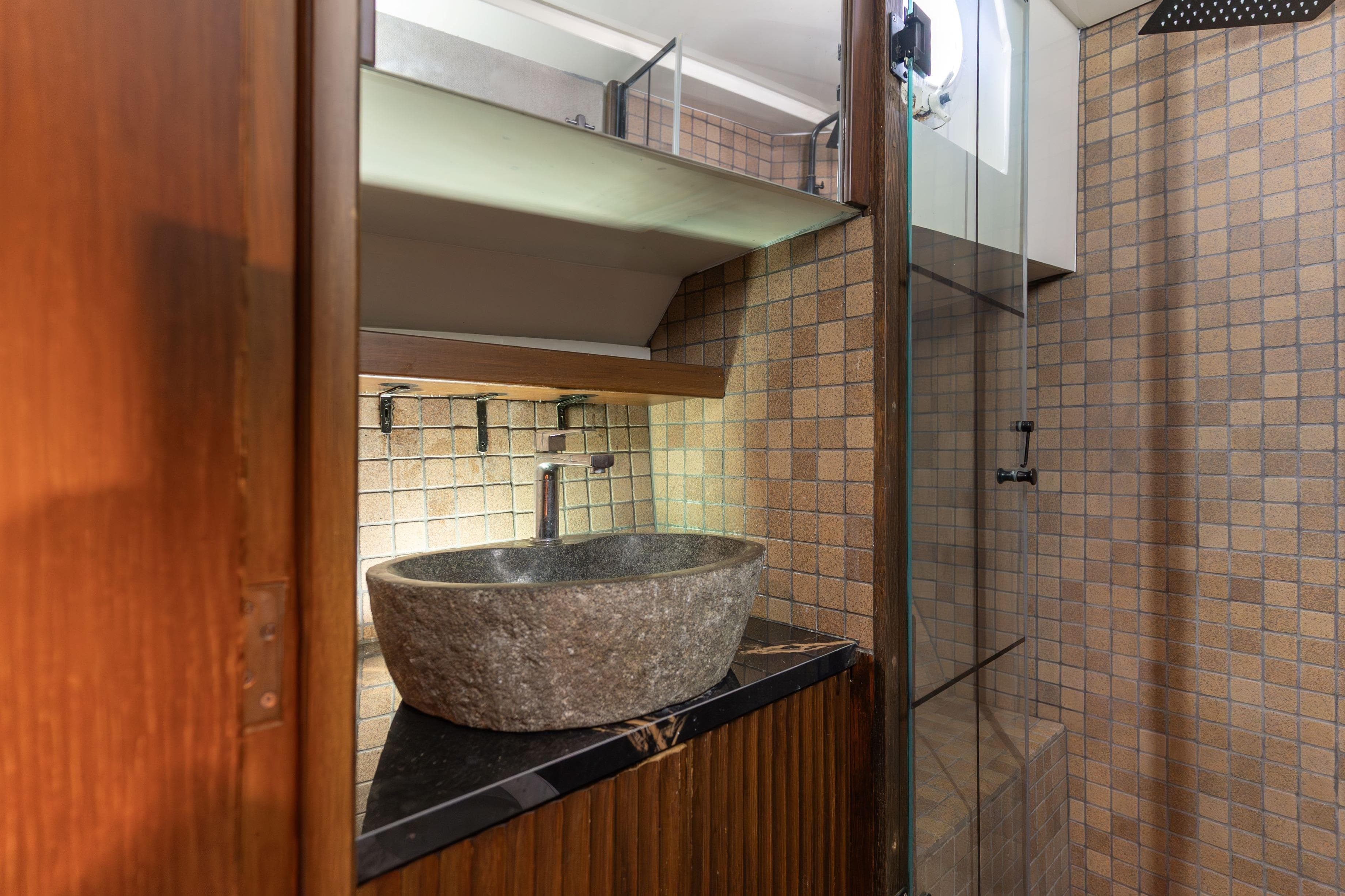 Modern bathroom with stone sink, glass shower, and tiled walls on a 1967 Cammenga model 61.