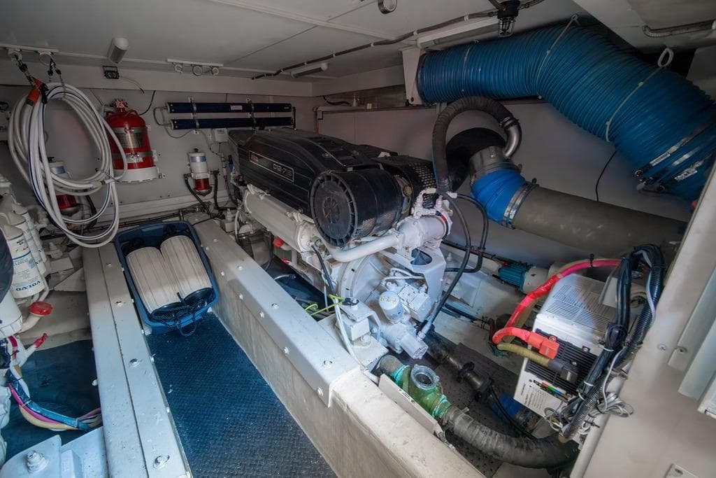 Engine room of a 2006 Marquis 59 yacht, featuring a diesel engine and fire safety equipment.