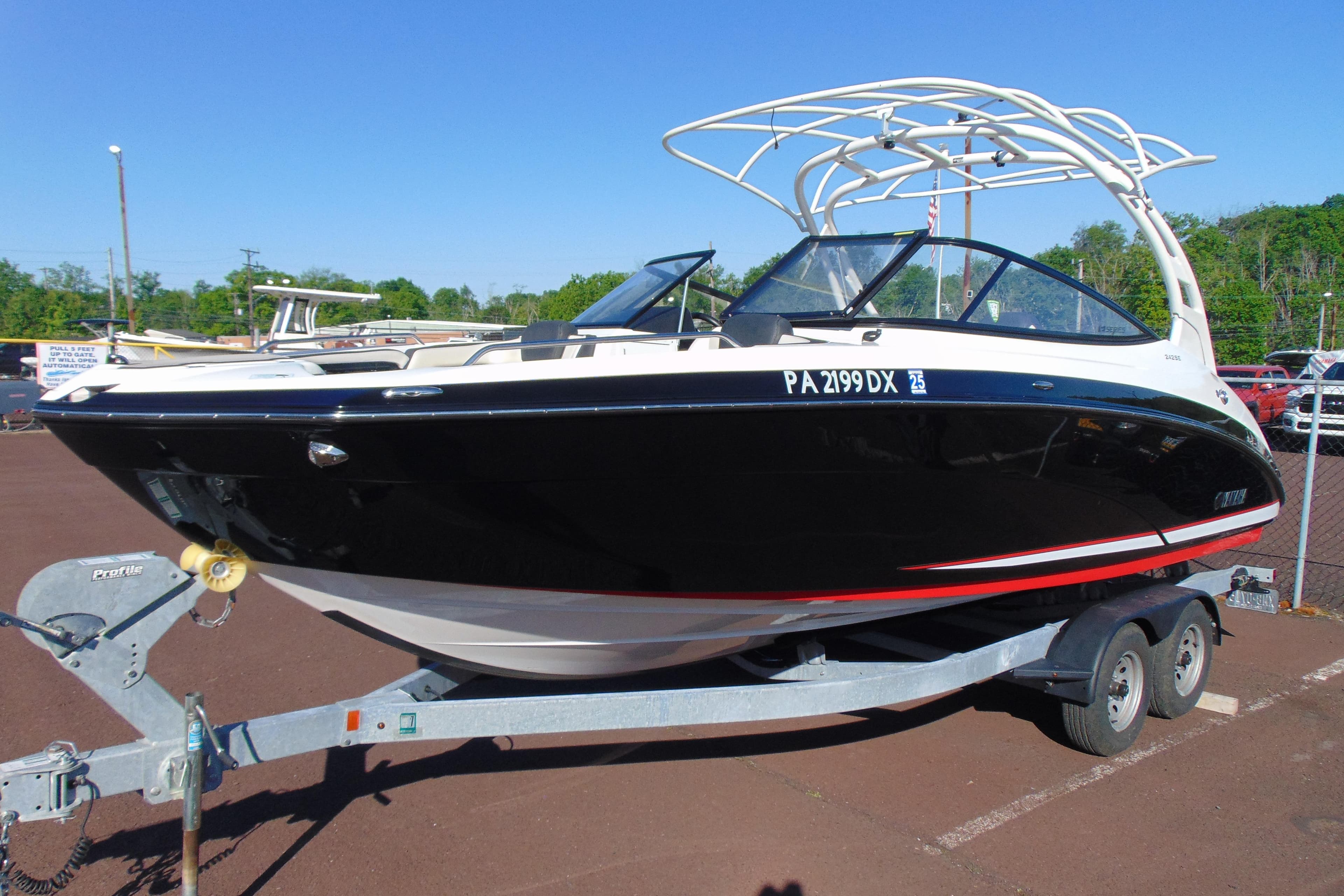2020 Yamaha Boats 242SE on trailer, black hull, parked outdoors.