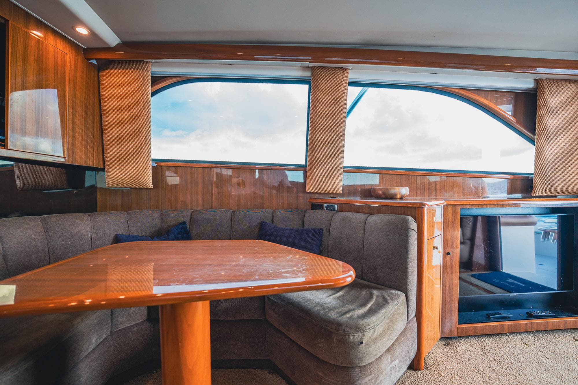 Interior of 2005 Viking 48 Convertible yacht with wooden table and plush seating.