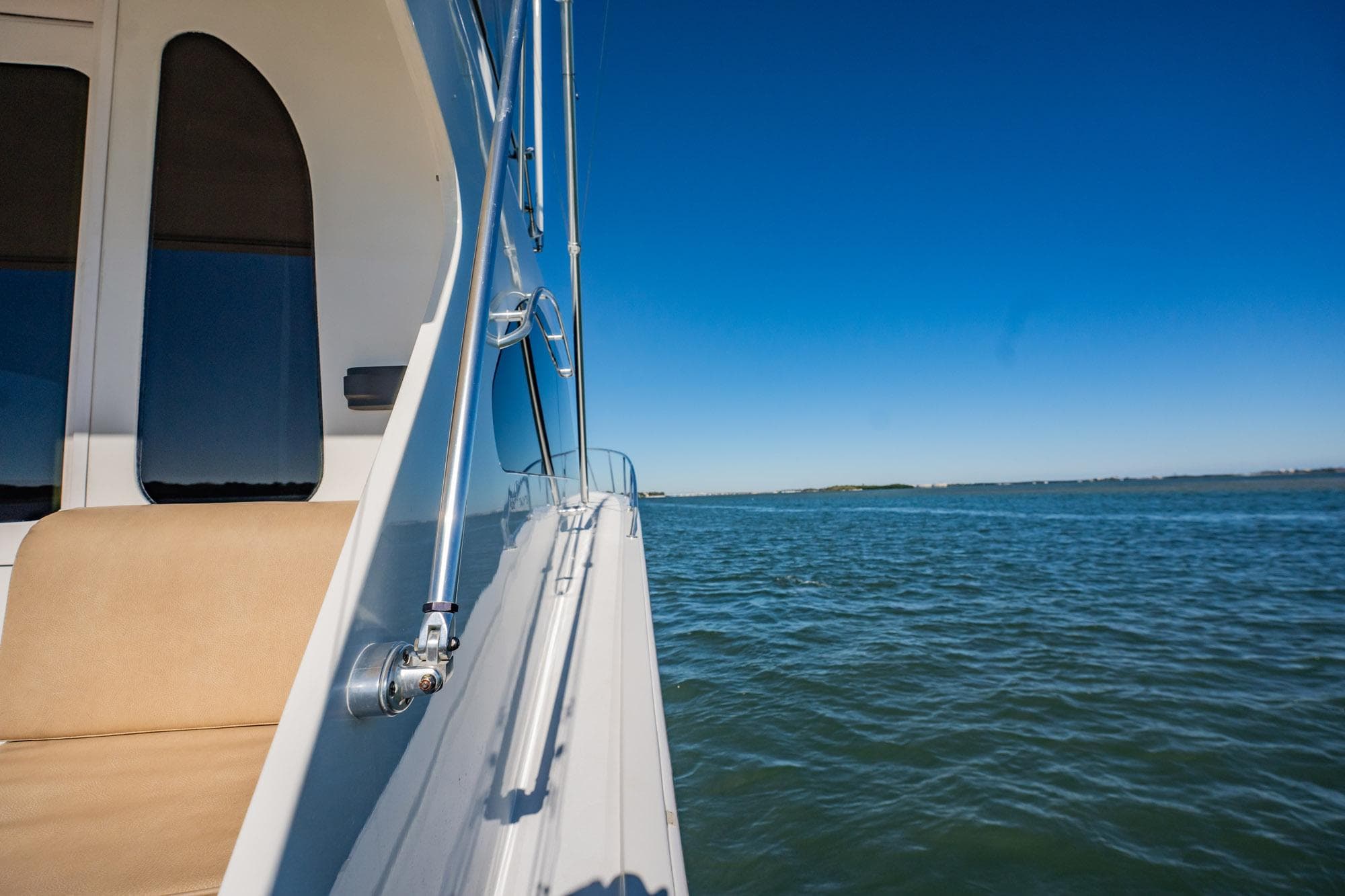 Side view of a 2001 Post 42 boat on calm waters under a clear blue sky.
