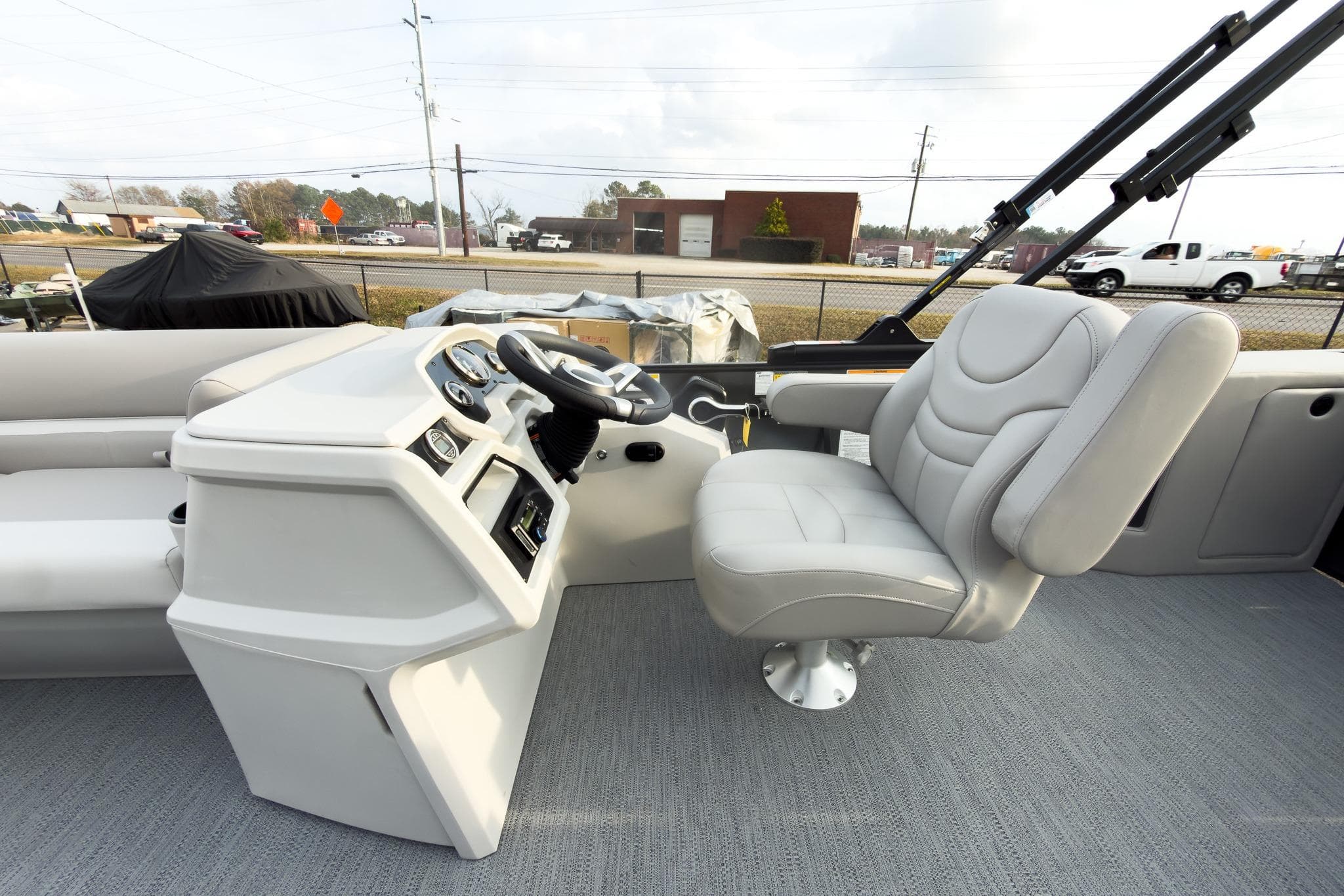 2026 Godfrey Sweetwater Xperience 22' Tritoon helm with plush captain's chair and modern controls.