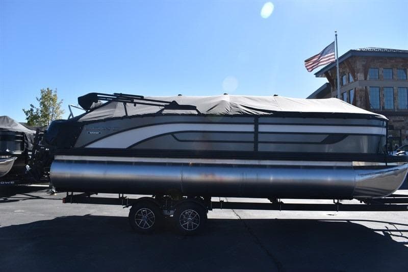 2026 Lowe SF 232 WT Sport Fish pontoon boat on trailer, covered and parked outdoors.