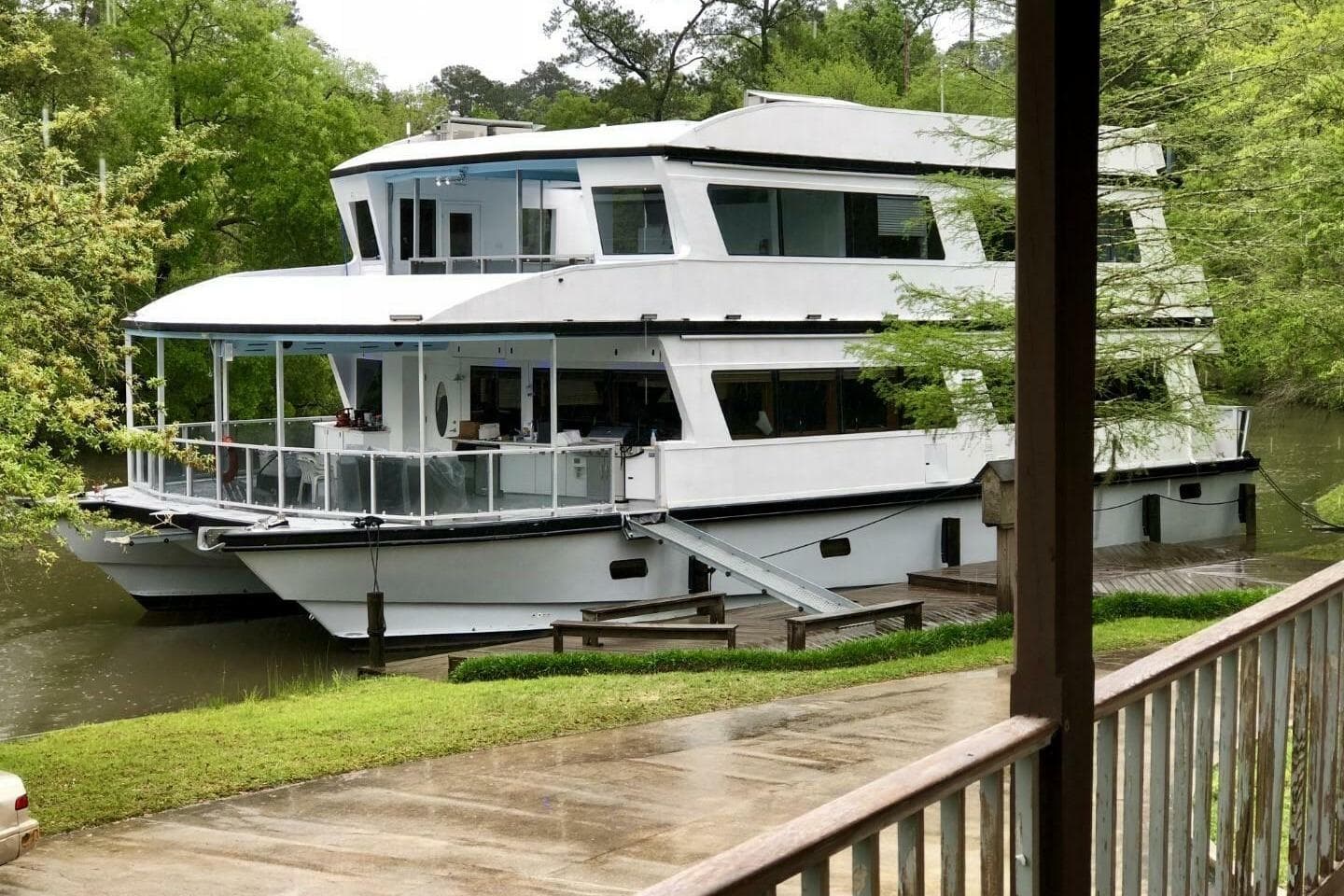 2018 Avenger Custom Luxury Catamaran Coastal Cruiser docked by lush greenery.
