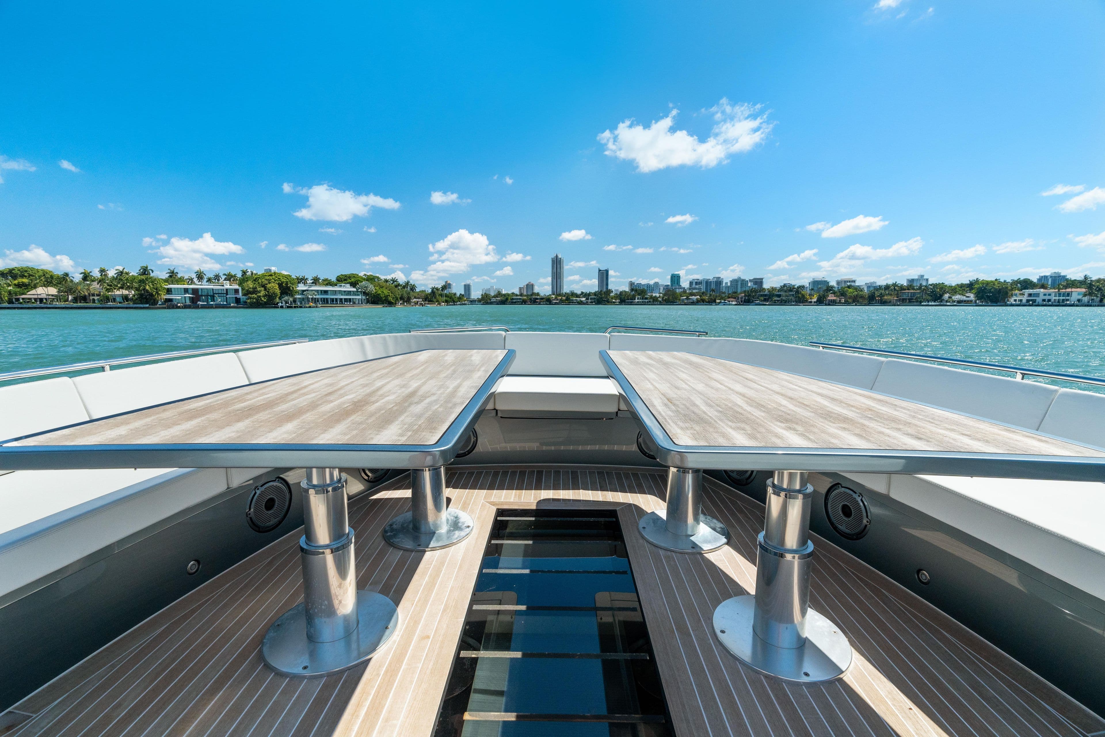 2024 CNM CONTINENTAL 54 SuperSport yacht deck with dual tables, overlooking serene waters.