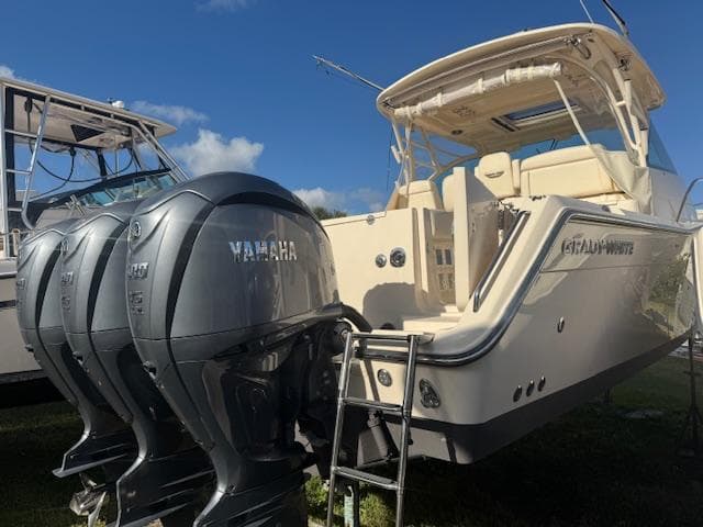 2021 Grady-White Express 370 boat with Yamaha outboard engines, docked under clear skies.