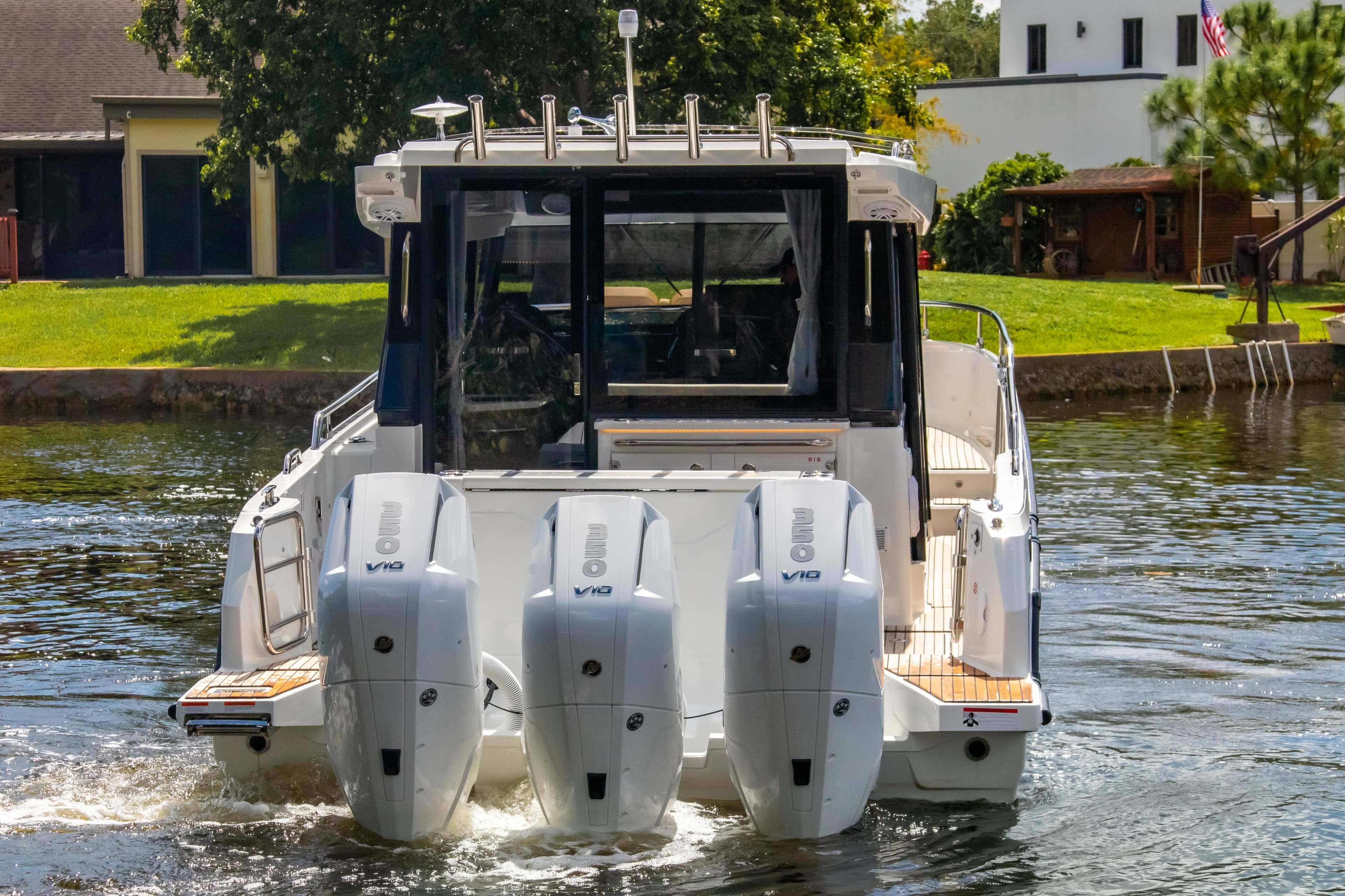2025 Wellcraft 38 Explorer boat with triple outboard engines on a calm waterway.