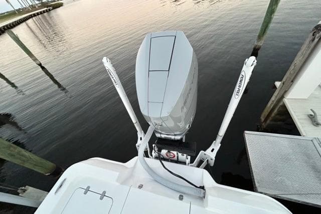 2025 Contender 26 Bay boat with outboard motor, docked on calm water.