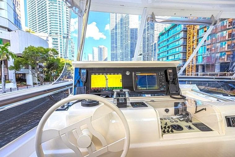 Cockpit view of 2011 Ferretti Yachts 830, featuring modern navigation equipment and urban skyline.