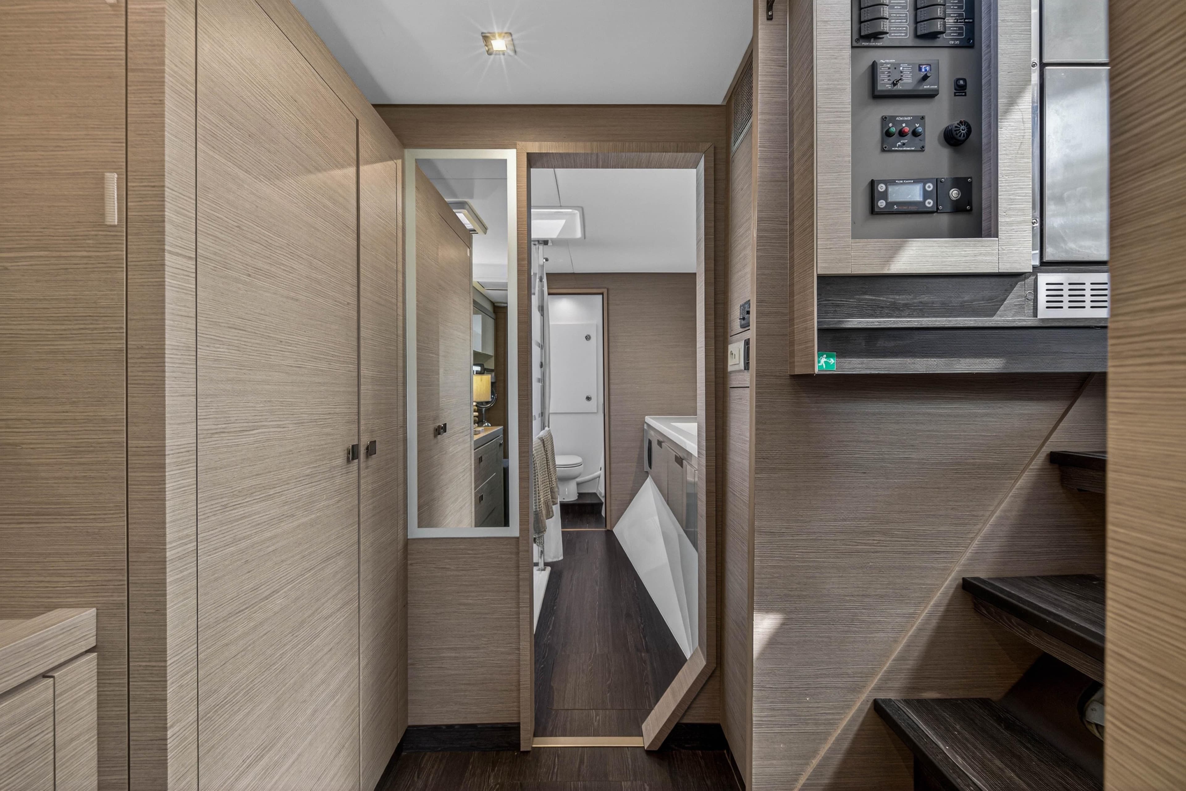 Interior of 2022 Fountaine Pajot Tanna 47 yacht, featuring modern wood paneling and control panel.