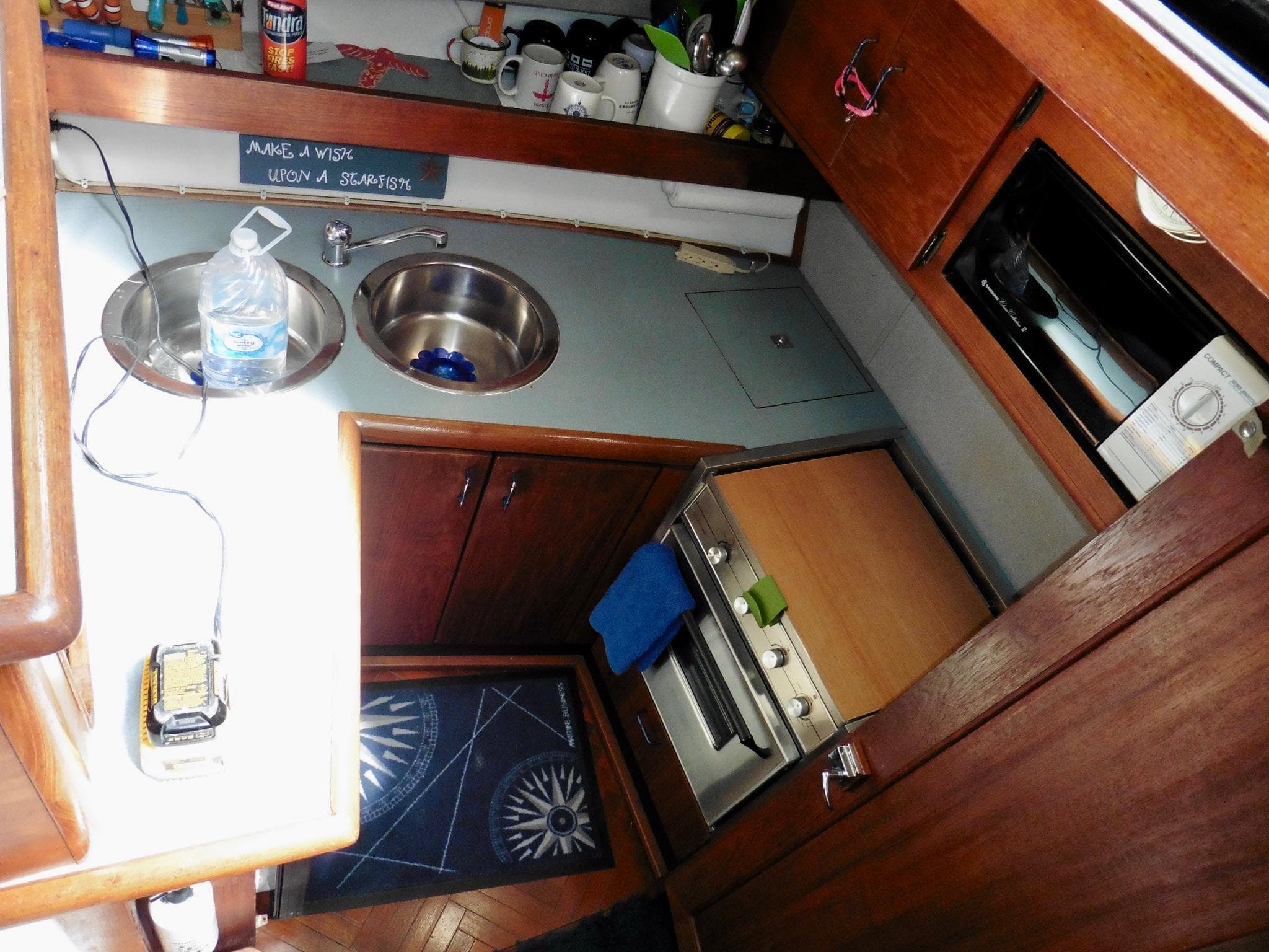 Interior of a 1992 Bayliner 3288 Motoryacht kitchen with sink, stove, and wooden cabinets.