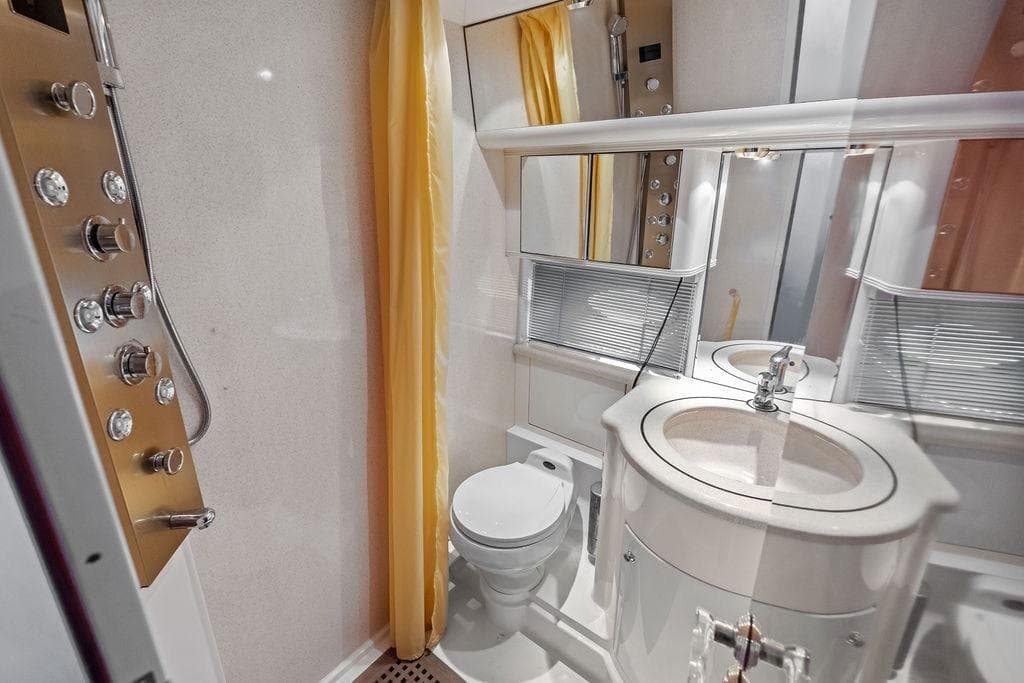 Luxurious bathroom in a 1999 Azimut 58 yacht, featuring modern fixtures and elegant design.