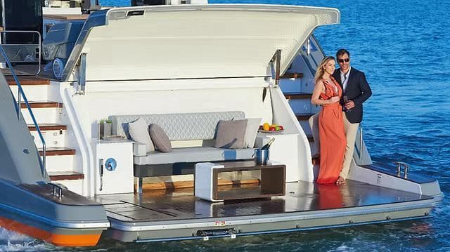 Couple enjoying luxury on Schaefer 770 yacht, 2026 model, with elegant deck seating.