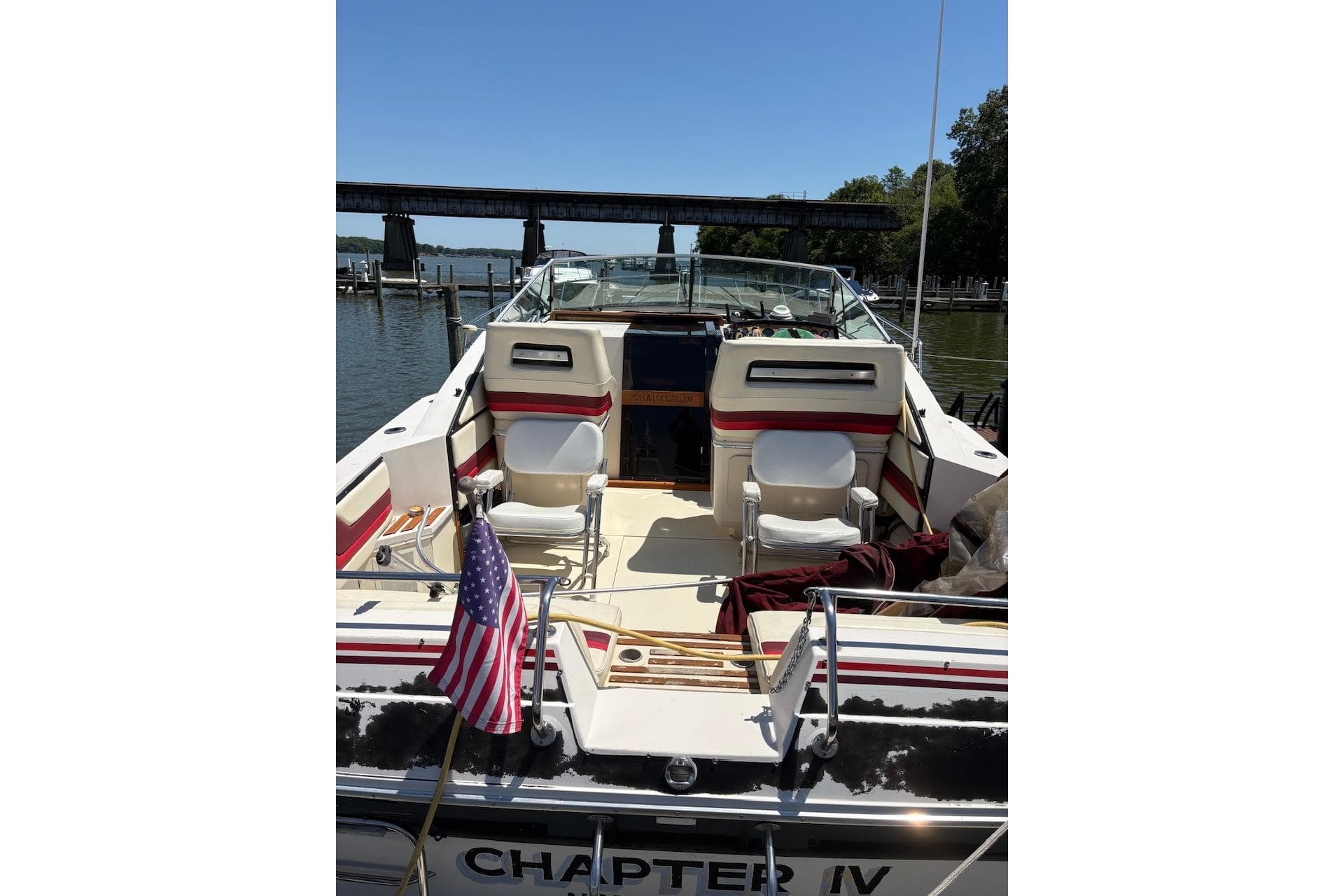 1986 Wellcraft 3200 St. Tropez boat docked, featuring spacious seating and American flag.