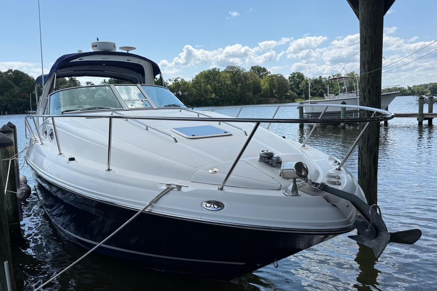 2006 Sea Ray Sundancer 320 docked on a serene lake under a clear sky.