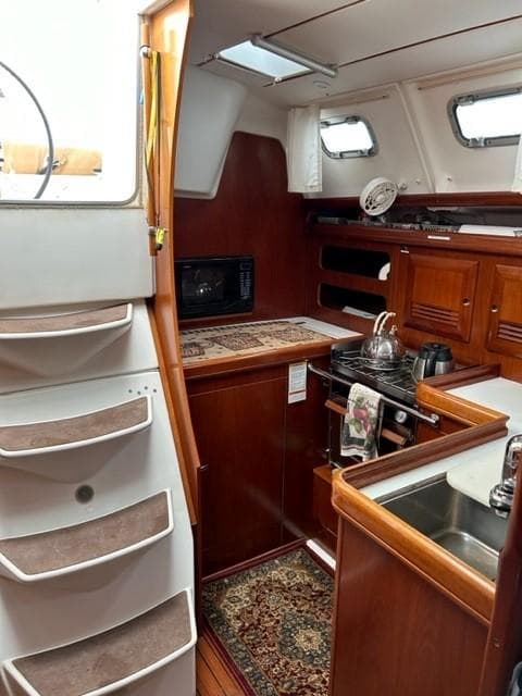 Interior of 2003 Beneteau 393 sailboat with kitchen and stairs.