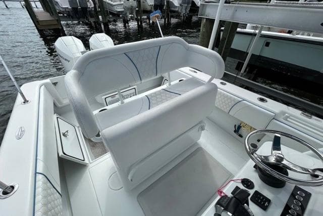 2023 Contender 28 Tournament boat interior with helm, seating, and dual engines at dock.
