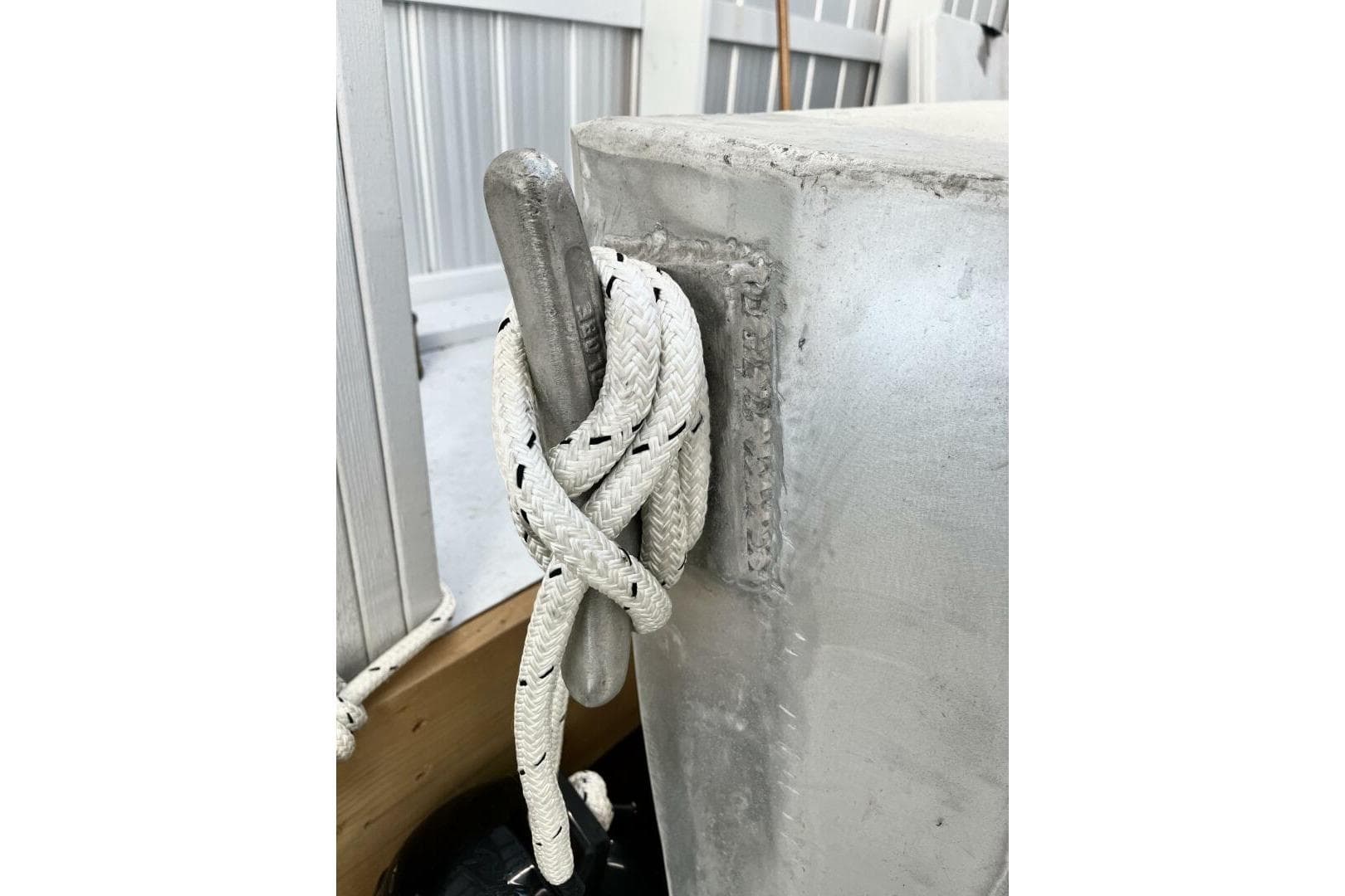 White rope tied around metal cleat on 1990 custom rebuilt dive boat.