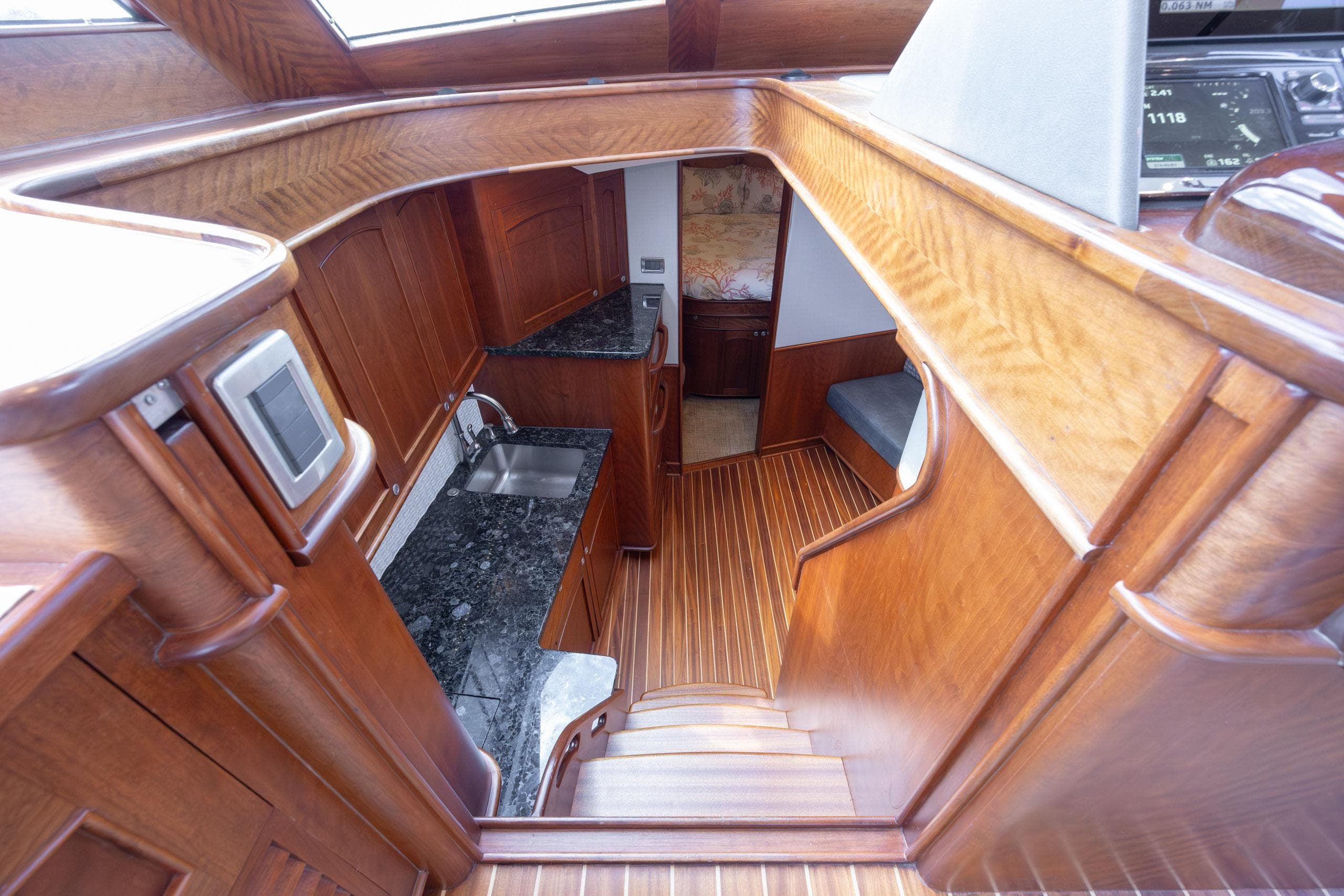 2015 Jarrett Bay Hardtop Express Sportfish interior with wood finish and compact kitchen area.