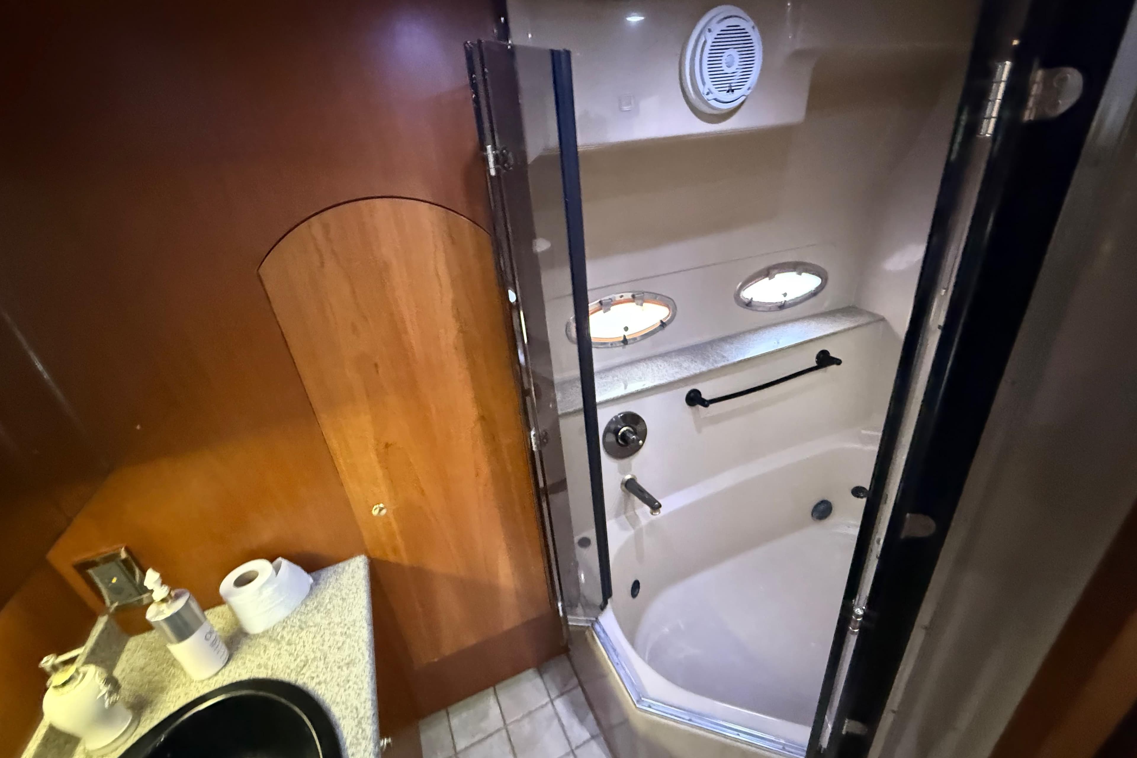 Luxurious bathroom in 2002 Cruisers Yachts 4450 Express Motoryacht with shower and portholes.