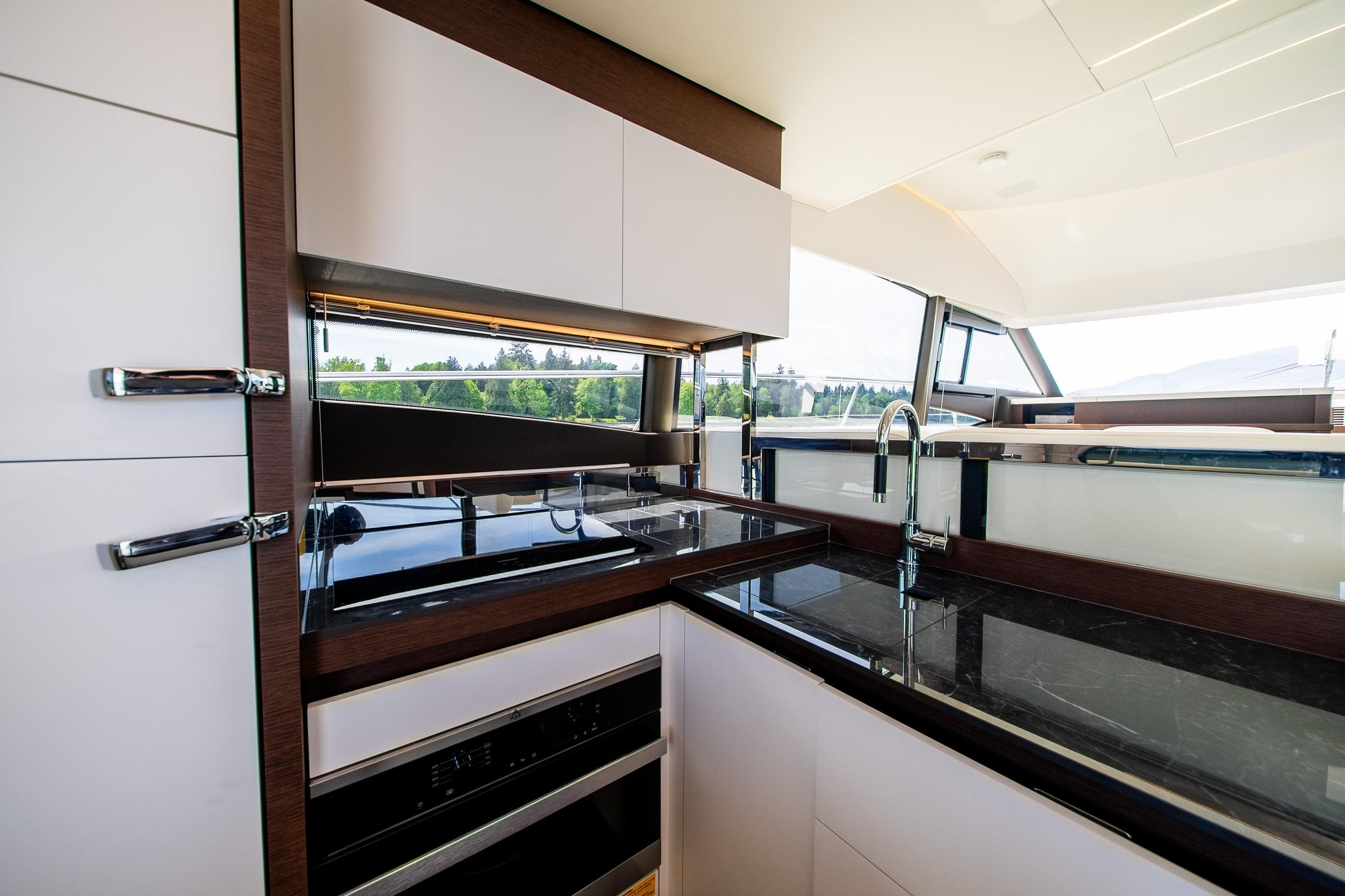 Luxurious kitchen interior of 2022 Prestige 520 yacht with modern appliances and sleek design.