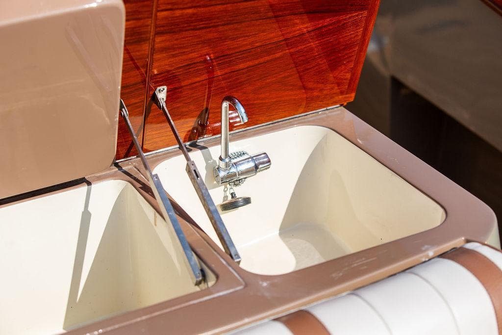 2003 Hinckley Talaria 29R boat sink with chrome faucet and wooden paneling.