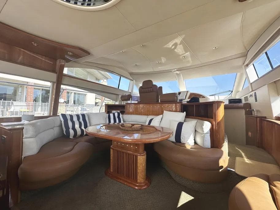 Luxurious interior of a 1996 Azimut 54 yacht with elegant seating and wooden accents.