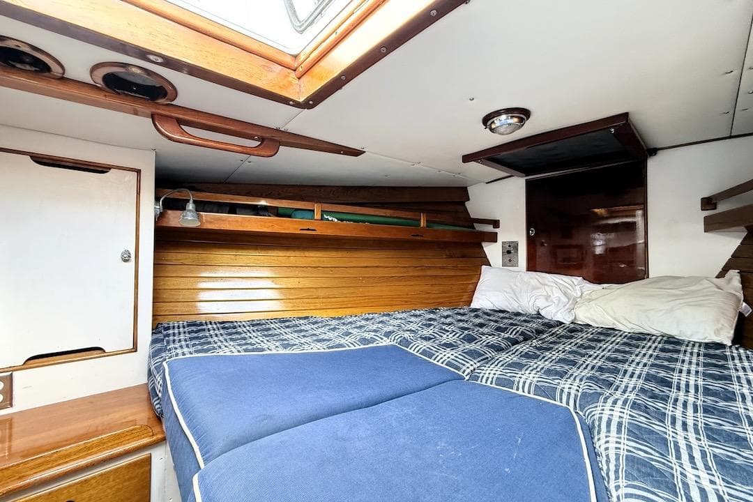 Cozy cabin interior of 1973 Sparkman & Stephens 55 Custom ketch with wooden accents and bedding.