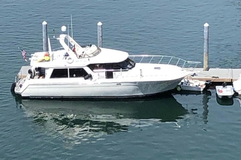 1994 Navigator Classic yacht docked at marina, reflecting on calm water.